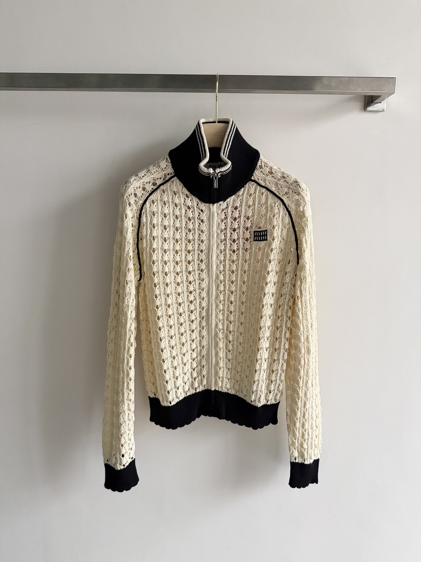 NO:822503,Miu Mi*2026 early spring series hollow knitted cardigan, beige main color + black contrasting edges, perfect score for sweet and cool retro style!  The hand-crocheted scallop texture is breathable and layered, making it super comfortable to wear in spring and summer. The stand-up collar + full zipper design can be worn alone or layered, and the square micro-mark on the chest is low-key and elegant. Pair it with a workwear skirt or a retro skirt, you can easily get college style or daily casual, practical and fashionable!  SML,,miumiu,skirts,19860909Miu Mi*2026早春系列镂空针织开衫,米黄色主调+黑色撞色边,甜酷复古风满分！手工钩织扇贝纹理,透气又有层次感,春夏穿超舒服.立领+全拉链设计,单穿or叠穿都OK,胸口方形微标低调显贵气.搭配工装半裙or复古裙装,轻松get学院风or日常休闲,实用又时髦！SML,,miumiu,skirts,,Women's clothing