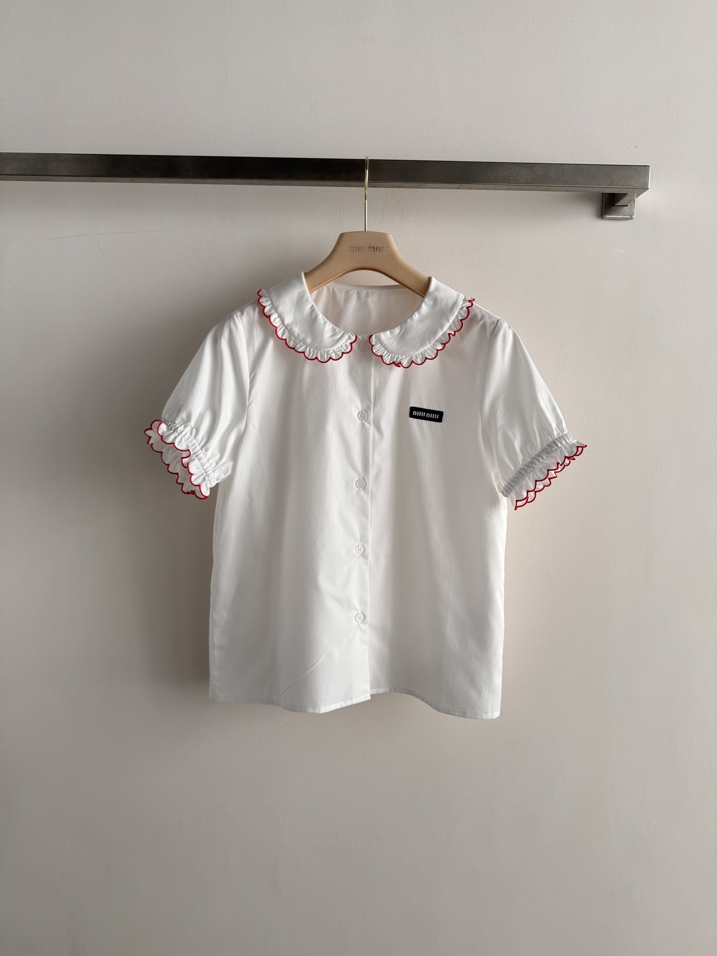 NO:825280,Miu Mi* new white short-sleeved shirt, classic doll collar + red trim, full of retro college style!  Lightweight cotton fabric, super breathable and comfortable to wear in summer. Brand logo on the chest, exquisite details, and puff sleeve design are sweet and playful, which can be easily used for daily commuting or leisure. Paired with pleated skirts or high-waisted pants, it directly adds youthful vitality. It is Miu's iconic item, a must-have for younger girls to wear SML, Miu Miu-clothing, loro piana, miumiu, skirts, shirts, T-shirt,19860909Miu Mi*新款白色短袖衬衫,经典娃娃领+红色镶边,复古学院风满满！轻薄棉质面料,夏天穿超透气舒适.胸前品牌标识,细节精致,泡泡袖设计甜美又俏皮,日常通勤或休闲都能轻松驾驭.搭配百褶裙或高腰裤,青春活力感直接拉满,是Miu标志性单品,减龄少女感穿搭必备SML,缪缪-服装,loro piana,miumiu,skirts,shirts,T-shirt,,Women's clothing