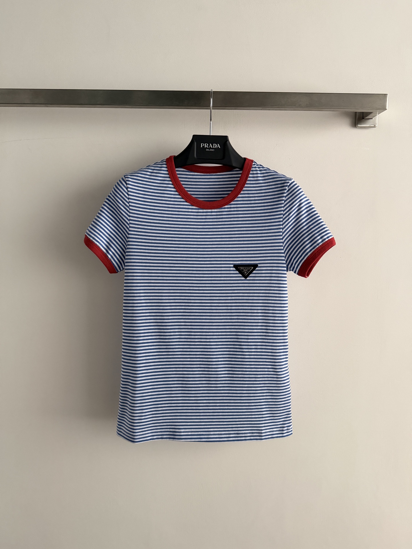 NO:855537,Prad*26 new blue and white striped short-sleeved T-shirt, embellished with red trim, full of French retro atmosphere. High-quality pure cotton knitted, soft and skin-friendly, super breathable, super comfortable to wear in summer!  The triangular logo on the chest makes the brand instantly recognizable. The slim fit is suitable for wearing alone or as a base layer. It is elegant when paired with a high-waisted skirt or casual and casual with jeans. It can be easily used for commuting, dating and daily life. It is a versatile tool for summer wardrobe!  SML,Prada-clothing,prada,prada,skirts,jeans,T-shirt,tees,t-shirt,19860909Prad*26新款蓝白条纹短袖T恤,红色边饰点缀,法式复古氛围感满满.高品质纯棉针织,柔软亲肤,透气性超赞,夏天穿超舒服！胸前三角标Logo,品牌辨识度直接拉满.修身版型,单穿或打底都很OK,搭配高腰裙优雅,配牛仔裤休闲随性,通勤、约会、日常都能轻松驾驭,是夏季衣橱百搭神器！SML,普拉达-服装,prada,prada,skirts,jeans,T-shirt,tees，t-shirt,,Women's clothing