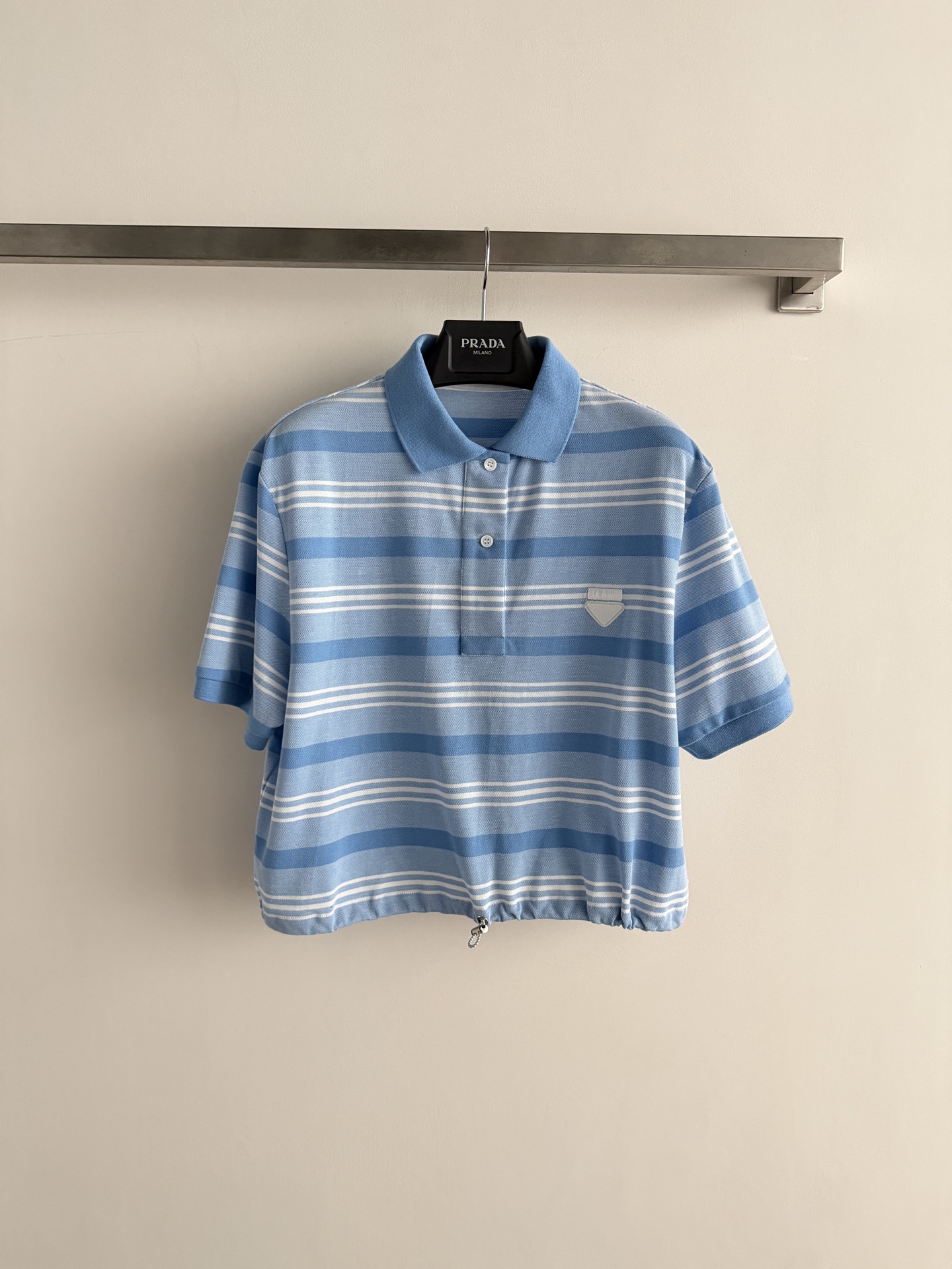 NO:855556,Prad*26SS blue and white striped Polo shirt, made of high-elastic knitted fabric, skin-friendly and breathable, super comfortable to wear in spring and summer!  The classic Polo collar + drawstring at the hem make it easy to adjust the shape, making you look slimmer and taller. The inverted triangle metal mark on the chest is very recognizable, and the blue and white stripes are refreshing and healing. It is full of college style and can be easily used for daily commuting and weekend outings. It looks great when worn alone or layered!  SML,Prada-clothing,prada,prada,19860909Prad*26SS蓝白条纹Polo衫,高弹针织面料,亲肤透气,春夏穿超舒服！经典Polo领+下摆抽绳,轻松调节版型,显瘦又显高.胸口倒三角金属标超有辨识度,蓝白条纹清新治愈,学院风满满,日常通勤、周末出游都能轻松驾驭,单穿或叠搭都很出彩！SML,普拉达-服装,prada,prada,,Women's clothing