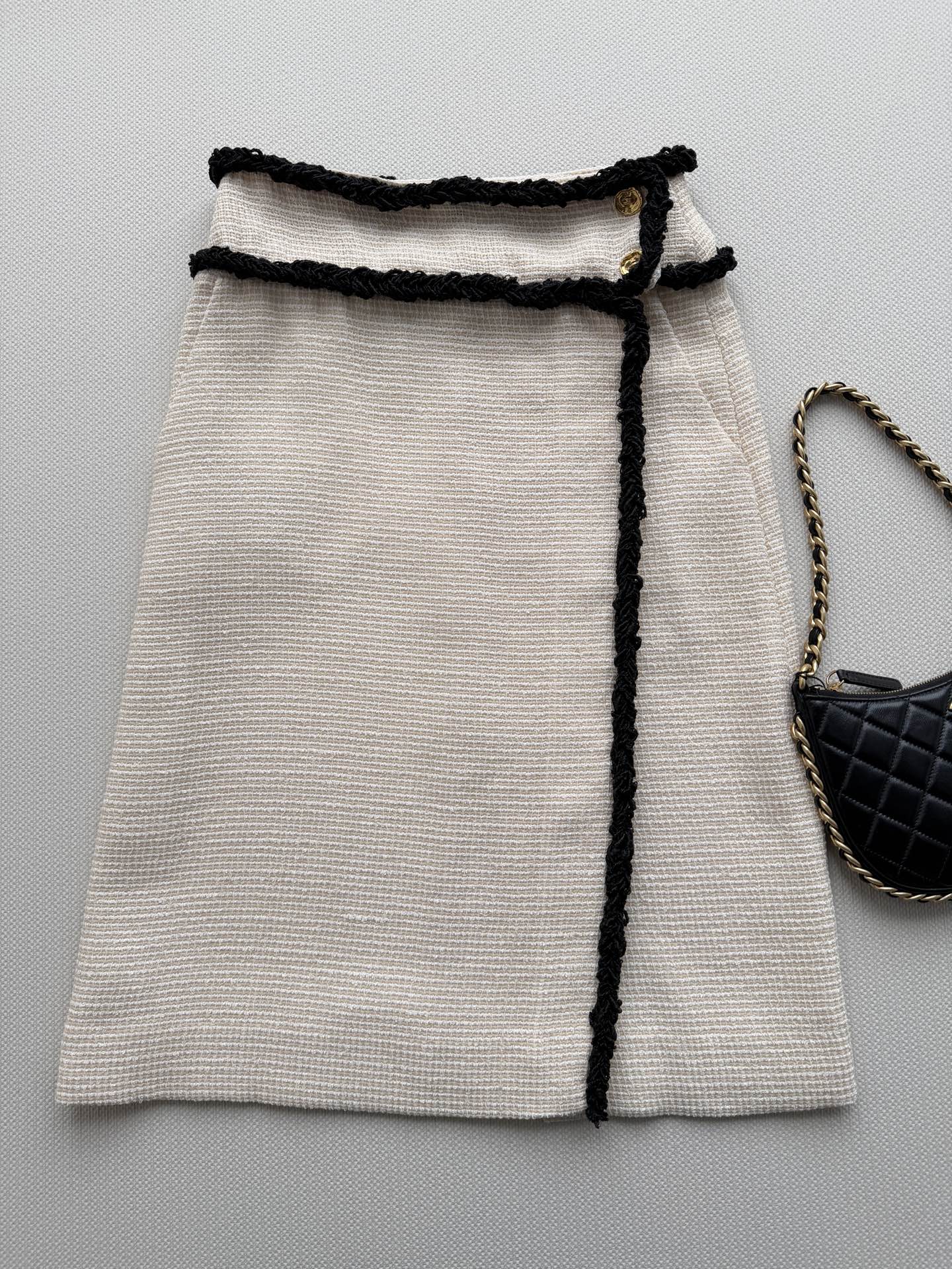 NO:855589,CHANE*2026 spring and summer off-white tweed skirt, black piping + gold buttons, full of classic elegance. The tweed material is soft and textured, the black piping outlines the lines, and the slit design is smart and practical. It can be easily controlled for daily commuting and formal occasions. Pair it with the same series of jackets for a more high-end look, and you can easily achieve the French relaxed atmosphere!  SML,Chanel-clothing,chanel,chanel,skirts,jackets & coats,19860909CHANE*2026春夏米白色粗花呢半裙,黑色滚边+金色纽扣,经典优雅气质满分.粗花呢材质柔软有肌理,黑色滚边勾勒线条感,开衩设计灵动又实用.日常通勤、正式场合都能轻松驾驭,搭配同系列外套更显高级感,法式松弛氛围轻松拿捏！SML,香奈儿-服装,chanel,chanel,skirts,jackets & coats,,Women's clothing