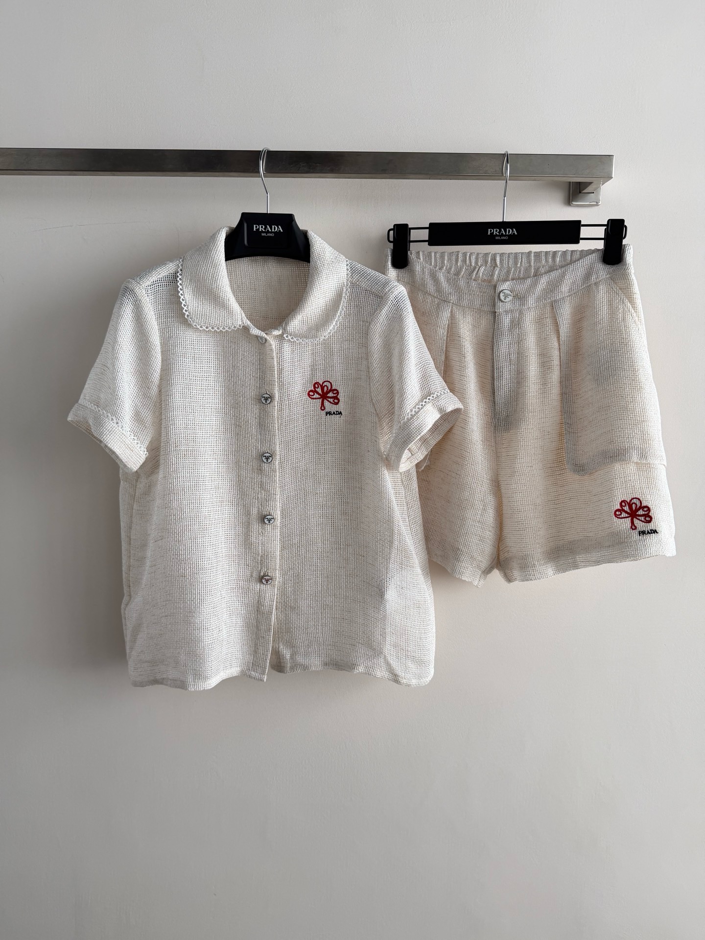 NO:855524,Prad's latest short-sleeved suit, the shirt has red four-leaf flower embroidery + white lace embellishment, perfect details. The shorts have the same embroidery, elastic waist design, the overall is simple and recognizable. It can be easily managed for daily leisure and vacation, comfortable and fashionable, easy to get a high-end look!  SML,Prada-clothing,prada,prada,shorts,shirts,T-shirt,19860909Prad*新款短袖套装,衬衫有红色四叶花刺绣+白色花边点缀,细节满分.短裤同款刺绣,松紧腰设计,整体简约又有辨识度.日常休闲、度假都能轻松驾驭,舒适又时髦,轻松get高级感穿搭！SML,普拉达-服装,prada,prada,shorts,shirts,T-shirt,,Women's clothing