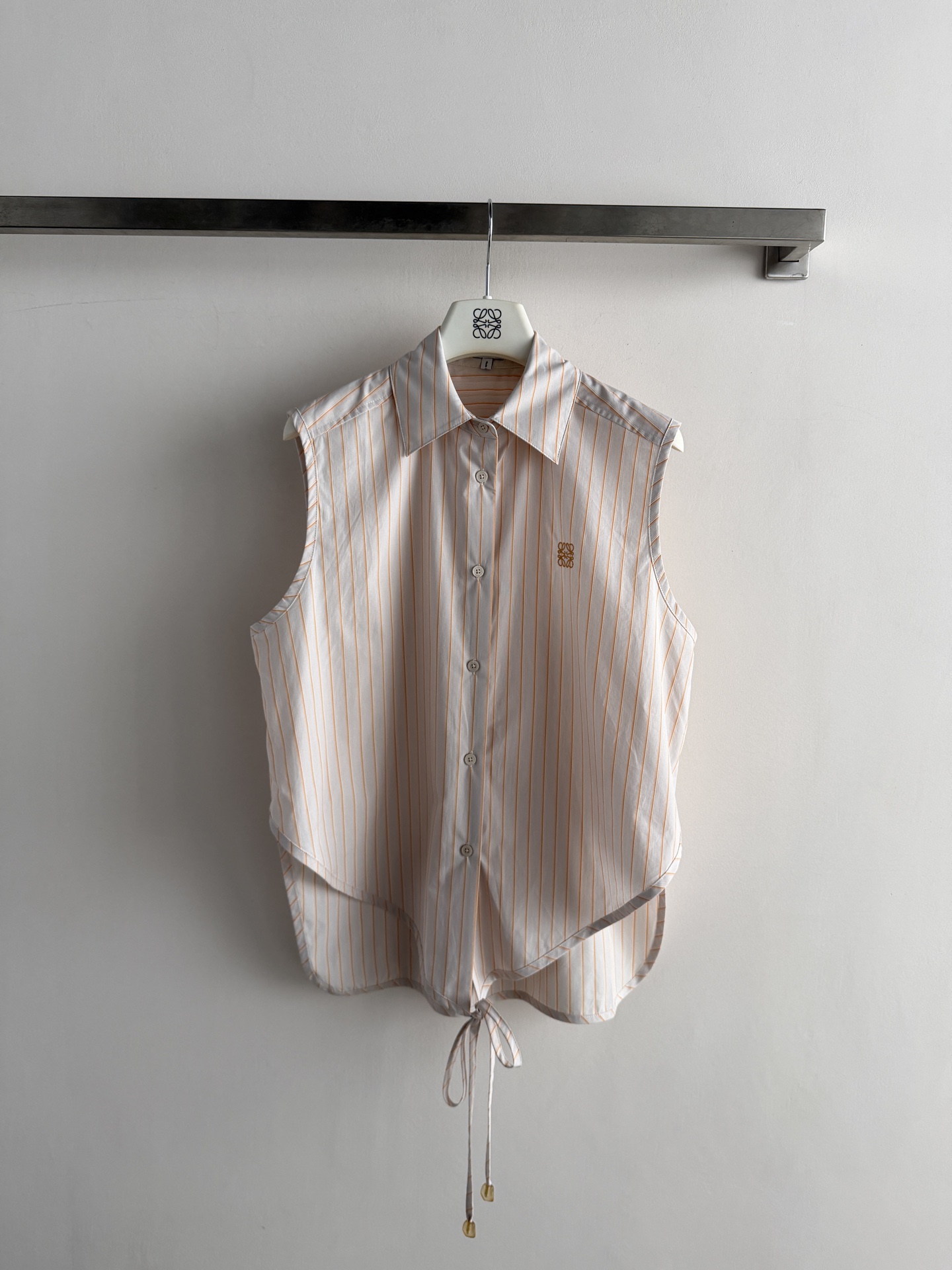 NO:856912,LOEW* series vertical striped sleeveless shirt, made of light and breathable fabric, super comfortable to wear in summer!  The sleeveless + lapel design is refreshing and elegant, and the stripes bring a sense of freshness. The logo embroidery on the chest is low-key and noble, and the lace-up design at the hem reduces age, making it easy to wear for commuting or vacation. Pair it with white shorts or a straw bag for a perfect summer relaxation!  SML, Loewe-clothing,loewe,loewe,espadrilles,shorts,shirts,19860909LOEW*系列竖条纹无袖衬衫,轻薄透气面料,夏天穿超舒服！无袖+翻领设计,清爽又优雅,条纹自带清新感.胸前logo刺绣低调显贵气,下摆系带减龄设计,通勤or度假都能轻松驾驭.搭配白色短裤或草编包,夏日松弛感满分！SML,罗意威-服装,loewe,loewe,espadrilles,shorts,shirts,,Women's clothing