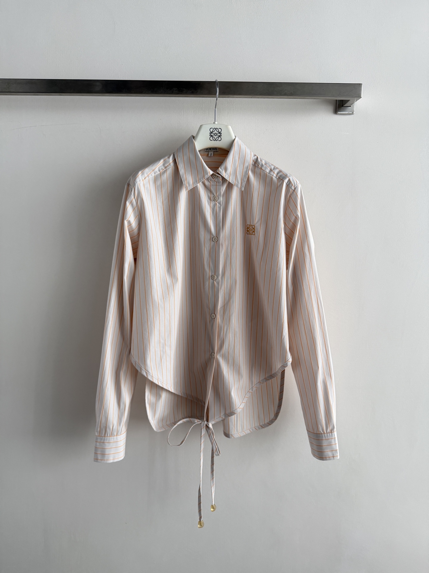 NO:857568,LOEW* series striped strappy shirt, with off-white base and light orange vertical stripes, the brand embroidery on the chest is very recognizable. Made of pure cotton, it is skin-friendly and breathable, making it super comfortable to wear in summer!  The side strap design can be adjusted freely, easily creating waist pleats, modifying the body shape, full of design, fashionable and practical ~ SML, Loewe-clothing, loewe, loewe, shirts,19860909LOEW*系列条纹绑带衬衫,米白底配淡橘竖条纹,胸前品牌刺绣超有辨识度.纯棉材质,亲肤透气,夏天穿超舒服！侧边绑带设计可自由调节,轻松打造腰部褶皱,修饰身形,设计感满满,时髦又实用～SML,罗意威-服装,loewe,loewe,shirts,,Women's clothing