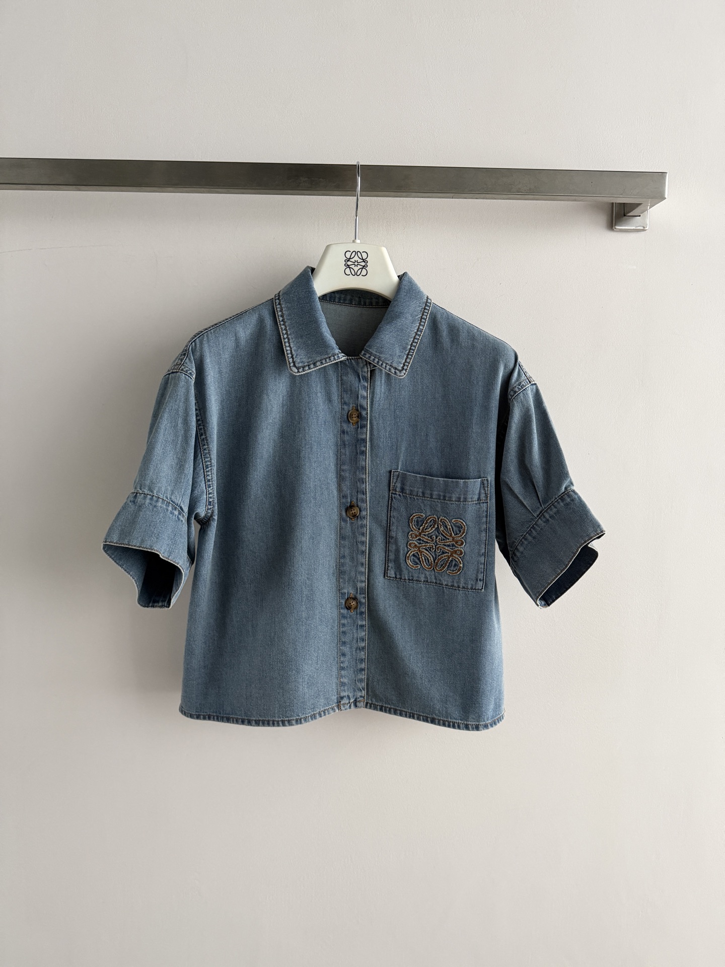 NO:857558,LOEW's latest series of denim shirts are made of washed light blue cotton fabric, soft and comfortable, and super refreshing to wear in summer!  Short sleeves + loose fit, super friendly to the body, easy to create a relaxed look. The brand embroidery on the chest is low-key and recognizable, with perfect details. Whether worn with a skirt, jeans or suit pants, you can easily switch between sweet and cool or commuting style, making it a versatile summer item!  SML, Loewe-clothing,loewe,loewe,skirts,jeans,shirts,T-shirt,business suit,19860909LOEW*新款系列牛仔衬衫,采用水洗浅蓝色棉质面料,柔软舒适,夏天穿超清爽！短袖+宽松版型,对身材超友好,轻松打造松弛感穿搭.胸前品牌刺绣低调又有辨识度,细节满分.无论搭半裙,牛仔裤还是西装裤,都能轻松切换甜酷or通勤风,是夏季百搭神器！SML,罗意威-服装,loewe,loewe,skirts,jeans,shirts,T-shirt,business suit,,Women's clothing