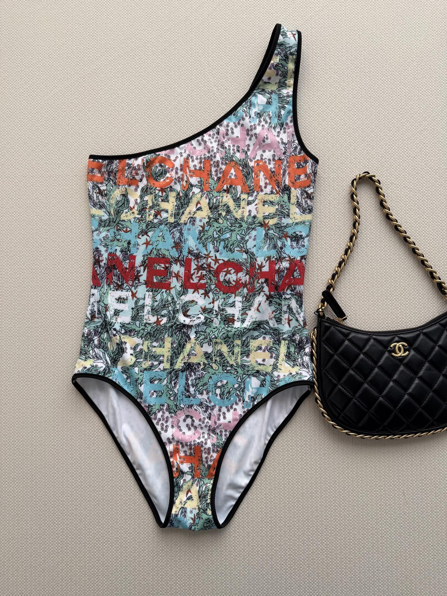 NO:893309,Chane*2026 Coco Beach series graffiti lettering one-piece swimsuit, made of high-elastic and quick-drying fabric, fit and comfortable, suitable for swimming and daily wear. Colorful letters + plant printing, full of summer atmosphere, energetic and advanced. One-shoulder asymmetrical design, modified collarbone, French elegance and modernity. Whether it is a beach vacation, a pool party or daily outings, it can be easily controlled, paired with shorts or skirts, it is extremely fashionable!  SML,,chanel,skirts,shorts,swimsuits,19860909Chane*2026 Coco Beach系列涂鸦字母连体泳衣,高弹速干面料,贴合舒适,适合游泳和日常穿搭.彩色字母+植物印花,夏日氛围感满满,活力又高级.单肩不对称设计,修饰锁骨,法式优雅与现代感兼具.无论海边度假、泳池派对还是日常出街,都能轻松驾驭,搭配短裤或裙装,时髦感爆棚！SML,,chanel,skirts,shorts,swimsuits,,Women's clothing
