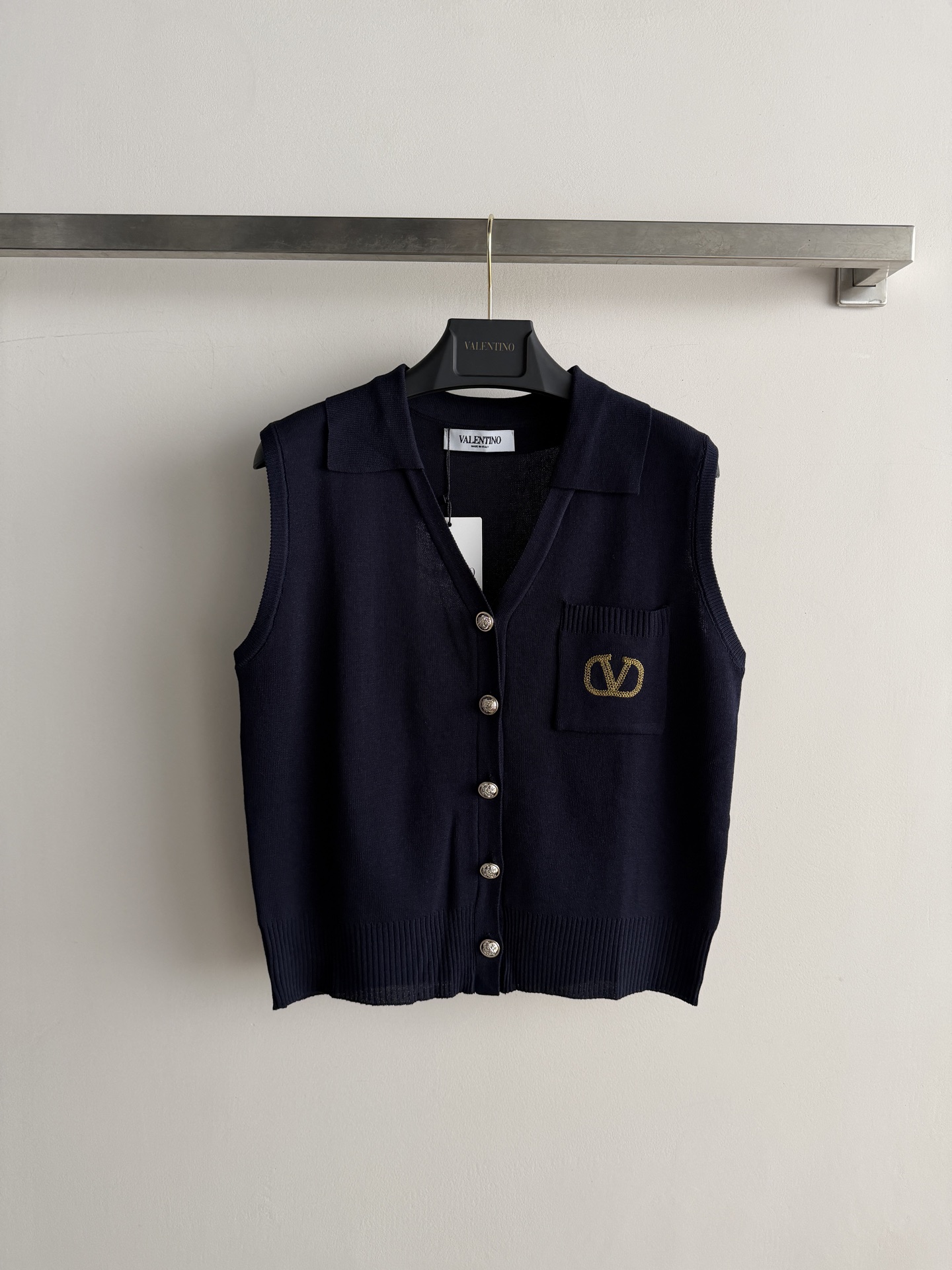 NO:906310,Valentin*'s new logo embroidered lapel knitted vest, V-neck single row of gold buttons + left chest pocket, gold brand embroidery on the pocket. Regular fit, easy to wear with white wide-leg pants + loafers/sandals - the most classic combination, clean and neat, suitable for commuting and dating. SML,,valentino,loafers,sandals,19860909Valentin*新款logo刺绣翻领针织马甲,V领单排金色纽扣+左胸口袋,口袋上有金色品牌刺绣常规版型好驾驭搭白色阔腿裤+乐福鞋/凉鞋——最经典的组合,上深下浅干净利落,通勤约会都合适.SML,,valentino,loafers,sandals,,Women's clothing