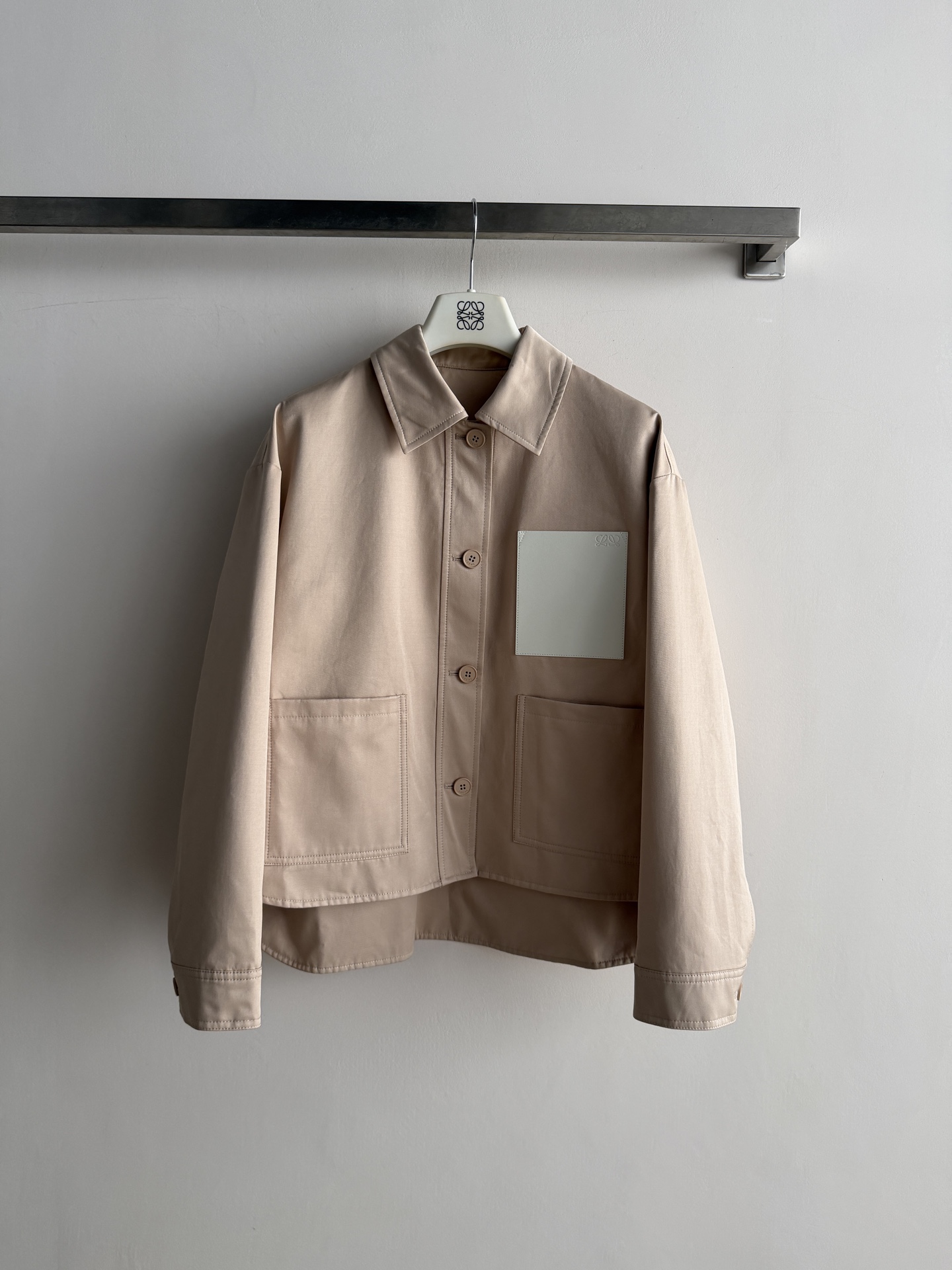 NO:951458,LOEW*26FW short leather label work jacket made of high-count twill cotton, stiff and windproof, thick texture, high-end and durable color, classic lapel shirt-style jacket, dropped shoulders and loose cut, short hem design, slightly slit at the back, casual and lazy. Leather label on the chest is embossed with the Anagram logo.  Double large pockets at the hem, buttons with natural wood texture, neat and neat routing, minimalist workwear style, suitable for wearing with T-shirts and sweaters, suitable for both commuting and leisure SML-,,loewe,jackets & coats,jackets & coats,shirts,tees,t-shirt,19860909LOEW*26FW皮质贴标工装短款夹克高支斜纹棉料,挺括防风,质感厚实,色调高级耐看经典翻领衬衫式外套,落肩宽松剪裁,下摆短款设计,后摆弧度微开叉,随性慵懒 胸前皮质贴标牌压印Anagram徽标装饰 下摆双插大口袋,原木质感纽扣,走线工整利落极简工装风,内搭T恤、针织衫都很合适,通勤休闲两不误SML-,,loewe,jackets & coats,jackets & coats,shirts,tees，t-shirt,,Women's clothing