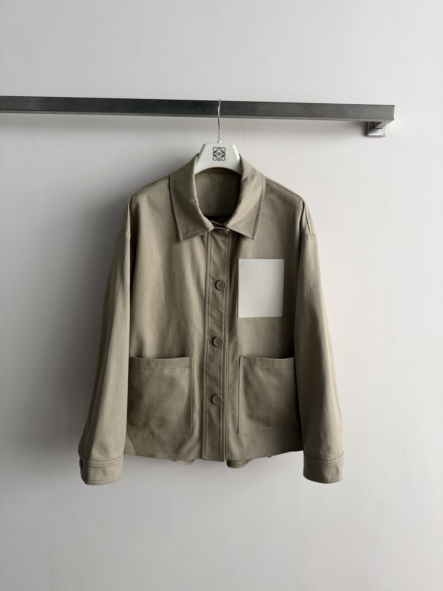 NO:944221,LOEW*26FW leather label work jacket is stiff and windproof, with a high-end and durable color and a classic lapel shirt-style jacket. It has dropped shoulders and a loose cut. The elasticated design at the back waist is casual and lazy. The leather label on the chest is embossed with the Anagram logo.  Double large pockets with logo letter buttons, neatly routed, minimalist workwear style, suitable for wearing with T-shirts and sweaters, suitable for both commuting and leisure SML-, Loewe-clothing, loewe, loewe, jackets & coats, jackets & coats, shirts, tees, t-shirt,19860909LOEW*26FW皮质贴标工装夹克外套挺括防风,色调高级耐看经典翻领衬衫式外套,落肩宽松剪裁,后腰位置松紧设计,随性慵懒 胸前皮质贴标牌压印Anagram徽标装饰 双插大口袋logo字母纽扣,走线工整利落极简工装风,内搭T恤、针织衫都很合适,通勤休闲两不误SML-,罗意威-服装,loewe,loewe,jackets & coats,jackets & coats,shirts,tees，t-shirt,,Women's clothing