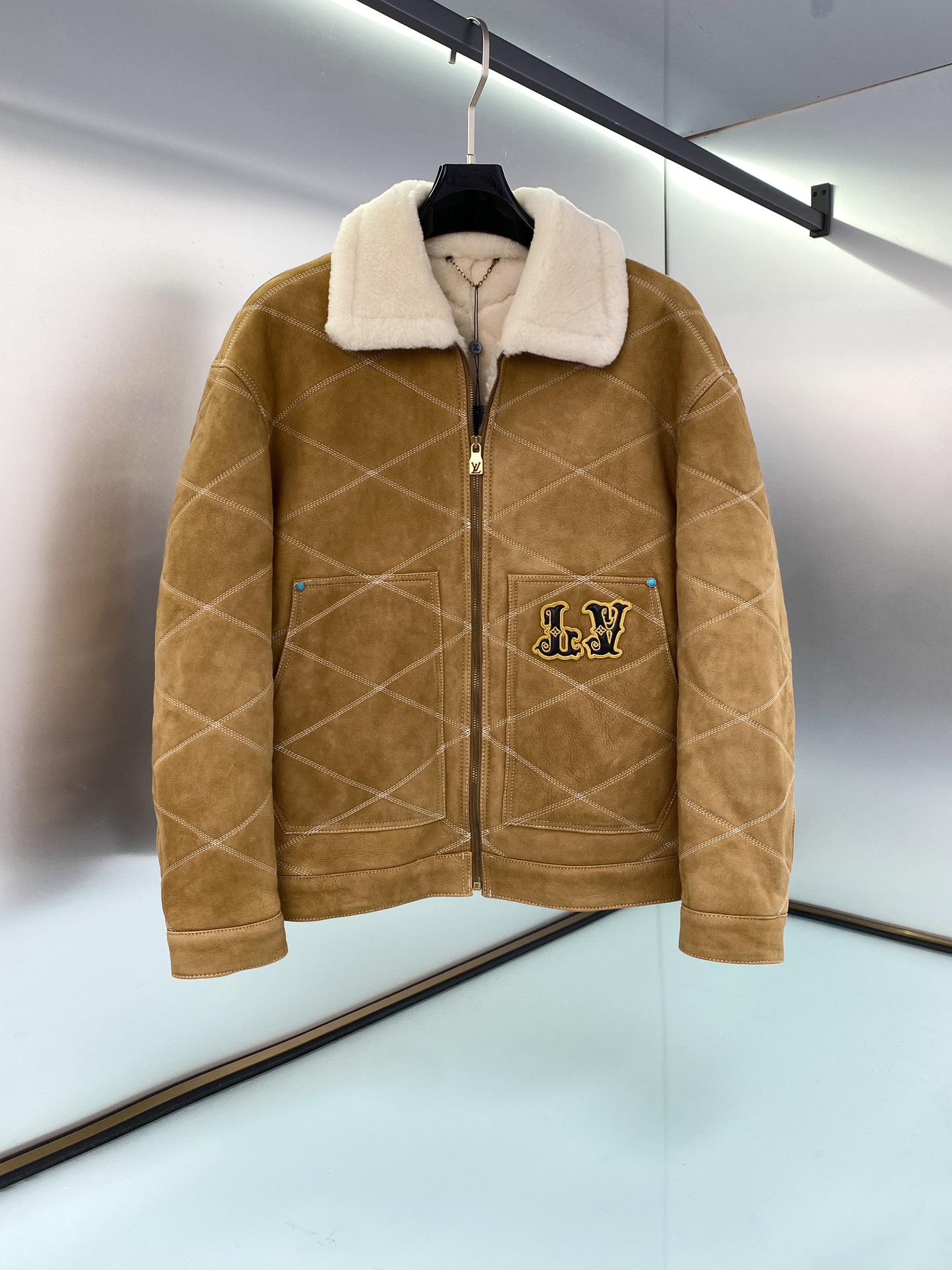 NO:675168,LV Men's Embroidered (Sheepskin) Work Tunic Jacket This shearling leather tunic jacket uses exquisite craftsmanship to create a casual silhouette, with all-over diamond stitching to pay homage to the lining design of the brand's traditional hard luggage. It is embellished with retro padded embroidered leather LV and Louis Vuitton patches on the front and back, highlighting the Far West theme of the autumn and winter show, and buttons and rivets add a sophisticated touch. Casual fit. The front left pocket has a padded embroidered LV patch.  Padded embroidered Louis Vuitton patch at rear Wool leather collar and lining Zip at front with LV stamped zipper pull Buttons and rivets Sizes 48-56,,louis vuitton,louis vuitton,jackets & coats,sheepskin,Top Customize119860909LV 男装刺绣（羊皮毛一体）工装束腰夹克 本款羊毛皮革束腰夹克采用精湛匠艺构筑休闲廓形,以全幅菱格缝线致敬品牌传统硬箱的内衬设计.前后点缀复古加衬刺绣皮革 LV 和路易威登贴饰,点明 秋冬秀场的 Far West 主题,纽扣和铆钉再添考究气息. 休闲版型 正面左侧口袋呈现加衬刺绣 LV 贴饰 后部呈现加衬刺绣路易威登贴饰 羊毛皮革衣领和内里 拉链前襟配有 LV 铭纹拉链头 纽扣和铆钉 尺码48-56,,louis vuitton,louis vuitton,jackets & coats,sheepskin,Top Customize1,Men's clothing