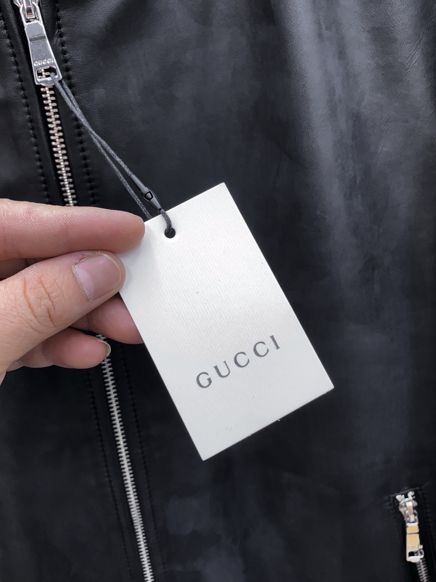 P1260 Gucci古驰纳帕皮飞行员夹克外套 。柔软纳帕皮革 + 羊毛棉混纺针织,质感与舒适度
外层选用柔软细腻的黑色纳帕羊皮,皮质纹理自然细腻,触感顺滑,兼具挺括感与柔韧度。表面光泽均匀,展现低调奢华的高级质感。 
针织拼接工艺 袖子与背部采用羊毛与棉混纺针织面料,针脚密实且富有弹性。在保持舒适穿着体验的同时,增强衣身的透气性与灵活性。立体剪裁版型直筒修身飞行员夹克版型,肩线挺括,身形利落。拼接工艺自然过渡 兼顾运动风与都市感。
门襟配备金属拉链,顺滑耐用。 袖口与下摆采用罗纹针织,并点缀 经典红绿织带,彰显标志性元素。 内里采用光滑里布拼接针织,穿着顺滑舒适。增添保暖性与耐穿性。