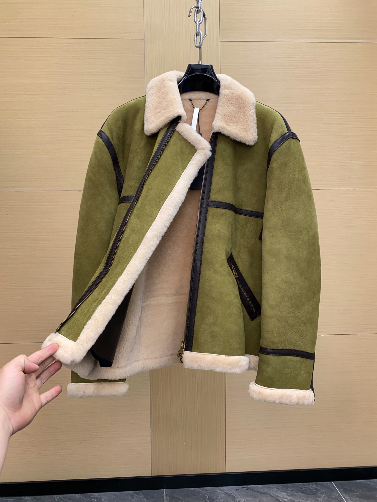 P2860 现货发售！LV 菲董操刀设计墨绿色麂皮羊羔毛皮毛一体外套夹克  本款 Bombardier 夹克取材舒软羊毛皮革，令后部饰钉描绘 2024 春夏秀场的LV Lovers 标识。柔暖绵羊毛内衬和衣领塑造经典男装廓形，大理石纹绒面外层呈现细腻肌理。撞色皮革饰带再添利落笔触。 标准版型 后部LV Lovers 标识点缀饰钉 尺码：48-56 