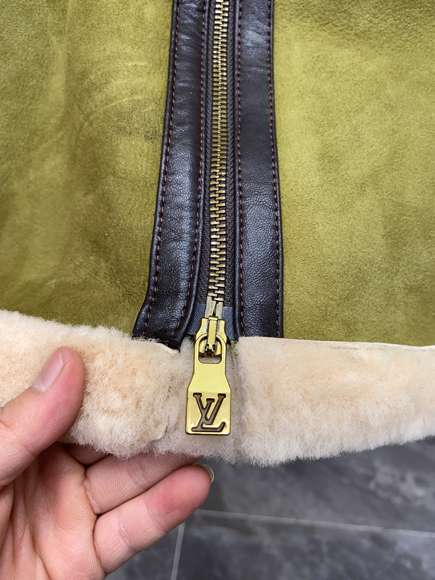 P2860 现货发售！LV 菲董操刀设计墨绿色麂皮羊羔毛皮毛一体外套夹克  本款 Bombardier 夹克取材舒软羊毛皮革，令后部饰钉描绘 2024 春夏秀场的LV Lovers 标识。柔暖绵羊毛内衬和衣领塑造经典男装廓形，大理石纹绒面外层呈现细腻肌理。撞色皮革饰带再添利落笔触。 标准版型 后部LV Lovers 标识点缀饰钉 尺码：48-56 