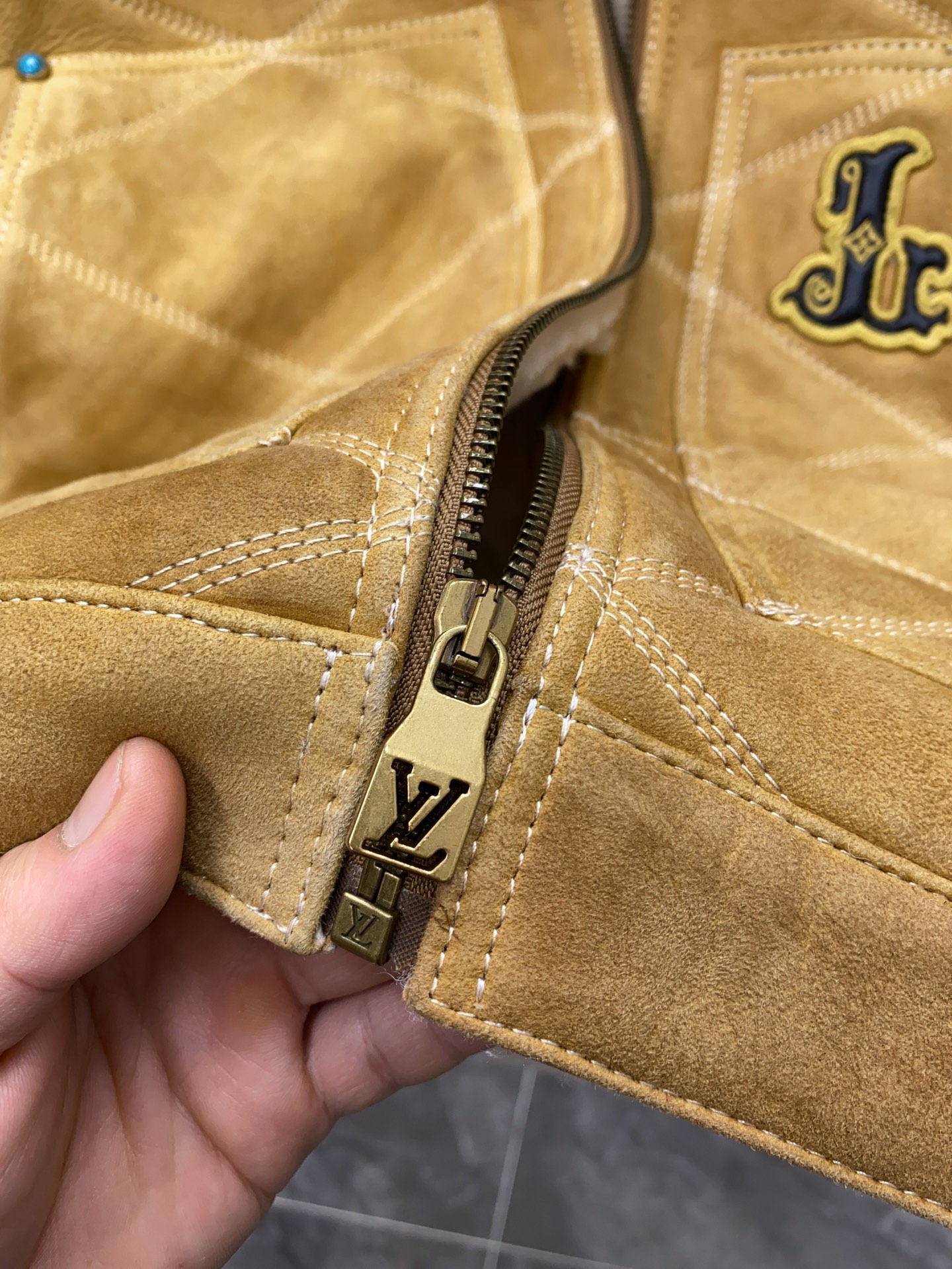 P2760 现货发售！LV 男装刺绣（羊皮毛一体）工装束腰夹克 本款羊毛皮革束腰夹克采用精湛匠艺构筑休闲廓形，以全幅菱格缝线致敬品牌传统硬箱的内衬设计。前后点缀复古加衬刺绣皮革 LV 和路易威登贴饰，点明 2025 秋冬秀场的 Far West 主题，纽扣和铆钉再添考究气息。
休闲版型 正面左侧口袋呈现加衬刺绣 LV 贴饰 后部呈现加衬刺绣路易威登贴饰 羊毛皮革衣领和内里 拉链前襟配有 LV 铭纹拉链头 纽扣和铆钉 尺码：48-56 