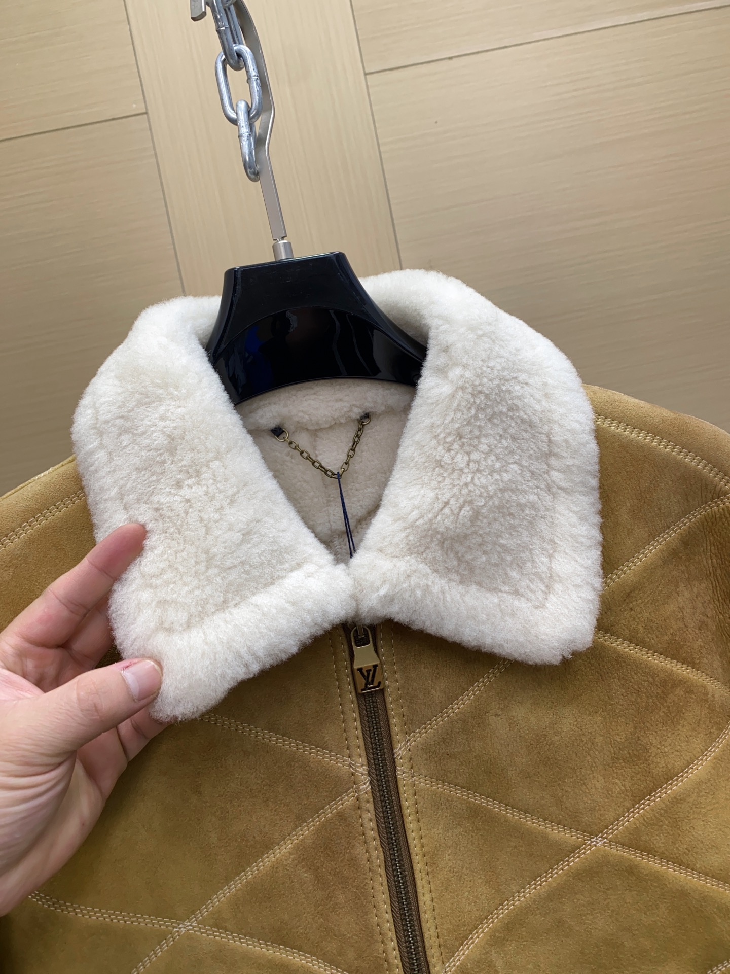 P2760 现货发售！LV 男装刺绣（羊皮毛一体）工装束腰夹克 本款羊毛皮革束腰夹克采用精湛匠艺构筑休闲廓形，以全幅菱格缝线致敬品牌传统硬箱的内衬设计。前后点缀复古加衬刺绣皮革 LV 和路易威登贴饰，点明 2025 秋冬秀场的 Far West 主题，纽扣和铆钉再添考究气息。
休闲版型 正面左侧口袋呈现加衬刺绣 LV 贴饰 后部呈现加衬刺绣路易威登贴饰 羊毛皮革衣领和内里 拉链前襟配有 LV 铭纹拉链头 纽扣和铆钉 尺码：48-56 