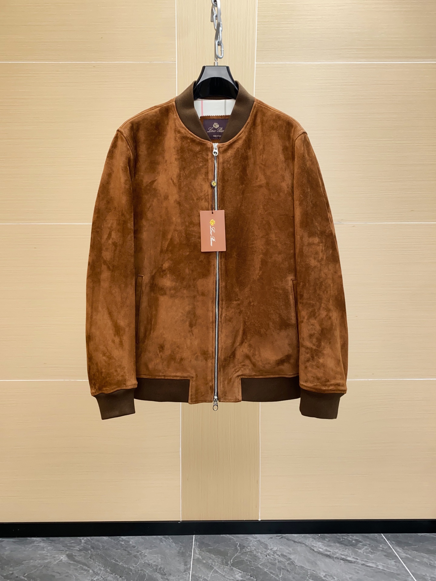 NO:688667,Loro Piana Men's Suede Zip Bomber Jacket | The brand's classic leather series. Loro Piana  The Ivy bomber jacket is made of soft leather to accompany you through cold winters and sharp spring chills. It is a loyal companion in the changing seasons. The design is inspired by the iconic bomber jackets made of technical fabrics in the past. It is made of high-quality water-repellent suede, with a preppy collar and lightweight padding to further enhance the soft texture of the leather material. Simple lines and simple design highlight the beauty of the material. Imported kid suede. The leather embryo comes from limited production areas in Europe, with dense fibers and a delicate feel. The suede is processed  The full-grain polishing and light frosting process ensures that the surface pile is uniform and smooth, and feels as soft as velvet. The leather is treated with vegetable tanning + light fattening, which not only retains flexibility, but also improves durability and color fullness. The dyeing process uses dip dyeing + manual coloring techniques, and the dye reaches the depth of the fiber, making the overall color saturation high and with a natural layering.  Different from the common surface spray dyeing on the market, this process can ensure that the color remains uniform after long-term wear, and is not easy to fade or have obvious color differences. Differences from the ordinary version on the market: Leather grade Loro Piana uses suede, with finer fluff. The ordinary version mostly uses adult cowhide or two-layer suede, and the difference in feel and breathability is obvious. Dyeing depth: The top model is deep-dyed in the fiber, and most of the market is surface-coated, which is easy to fade and fluff. It feels shiny.  Branded models will show soft suede light and shadow under natural light, while ordinary versions are mostly dull matte. The leather with top-quality durable craftsmanship has better toughness and is not easy to harden and crack after long-term wear. The texture of the market version often deteriorates after a short time of use. The inner craftsmanship is high-count cotton and silky blended fabrics, breathable and skin-friendly, and avoids stuffiness when worn. The classic plaid weaving process not only improves the overall grade, but also ensures the stiffness and wear resistance of the interior.  Original custom-made horn buttons, engraved with the 'Piana' brand on the front, with a warm texture and natural luster. Exclusive custom-made hardware zippers, engraved with the brand logo, with smooth teeth and strong durability. The cuffs & hem are made of Wish virgin wool knitted ribbing, which has good elasticity and fits the wrist and waist, which is comfortable and can effectively maintain the silhouette.,,loro piana,jackets & coats,cowhide,sheepskin,Top Customize119860909Loro Piana 诺悠翩雅男装绒面革拉链飞行员夹克 ｜ 品牌的经典标杆级皮革系列. Loro Piana Ivy飞行员夹克采用柔软皮革制成,陪伴您度过寒冷冬日和料峭春寒,是四季变换的忠实伴侣.设计灵感源自过去采用科技面料制作的标志性飞行员夹克,采用优质防泼水绒面革制成,配以学院风衣领和轻盈填充物,进一步提升皮革材质的柔软质感.简洁线条和简约设计彰显材质之美. 进口 小山羊绒面革.皮胚来自欧洲限定产区,纤维致密且手感细腻.绒面经过 全粒面打磨与轻磨砂工艺,确保表层绒毛均匀、顺滑,触感如丝绒般柔和.皮革经 植物鞣+轻度加脂工艺 处理,既保留了柔韧性,又提升了耐用度和色泽饱满度. 染色工艺使用 浸染+ 手工上色 技法,染料直达纤维深处,使得整体颜色饱和度高,并具备自然的层次感. 与市面常见的表面喷涂染色不同,这种工艺能保证长期穿着后依旧保持色泽均匀,不易掉色或出现明显色差. 与市面普通版本的区别 皮胚等级Loro Piana 采用小山羊皮,绒毛更细腻,普通版本多使用成年牛皮或二层翻毛,手感与透气性差距明显. 染色深度 顶级款为纤维深层浸染,市面多数为表面涂层,容易褪色、起毛.触感光泽 品牌款在自然光下会呈现柔和的绒面光影,而普通版本多为死板的哑光 .耐用性顶级工艺的皮料韧性更佳,久穿不易硬化开裂,市面版往往使用时间短后质感下降. 内里工艺 高支棉质与丝滑混纺面料,透气亲肤,避免穿着闷感.经典格纹织造工艺,既提升整体档次,也保证了内里的挺括度与耐磨性. 原版定制牛角纽扣,正面刻有 “ Piana” 品牌字样,质感温润,光泽自然.专属定制五金拉链,刻有品牌 Logo,齿口打磨顺滑,坚固耐用.袖口 & 下摆 采用 Wish 初剪羊毛针织罗纹,弹性佳、贴合手腕腰身,既舒适又能有效保持廓形.,,loro piana,jackets & coats,cowhide,sheepskin,Top Customize1,Men's clothing