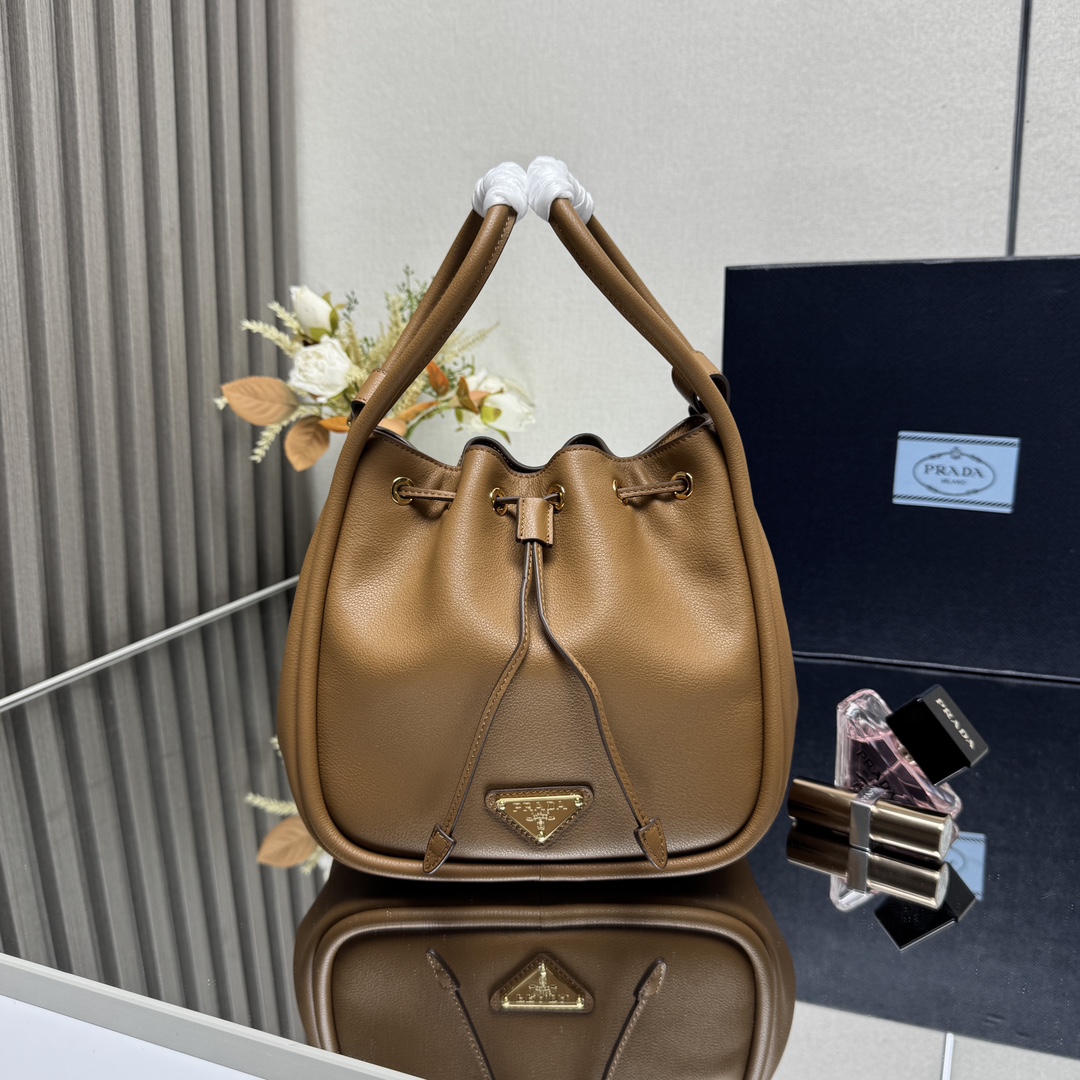 NO:659245,[Top original order] New bucket bag 1BE087 caramel. This bucket bag is made of chic and noble calfskin. It is equipped with a detachable long shoulder strap and can be carried in various ways. It can be carried by hand or on the shoulder. The bag mouth is designed with a drawstring. It is highly functional and perfect. The space is large. The upper body effect is good-looking and fashionable. Baby, hurry up and get it. Dimensions: length 22x height 21x bottom 10.5cm, PRADA, prada, cowhide19860909【顶级原单】新款水桶包1BE087焦糖这款水桶包采用别致高贵小牛皮,配有一条可拆卸长肩带,多种背法.又可手提又可肩带,袋口为抽绳设计,功能性強,太完美空间大,上身效果好看又时尚,宝宝们,赶紧入手吧尺寸长22x高21x底10.5cm,PRADA,prada,cowhide,Bag