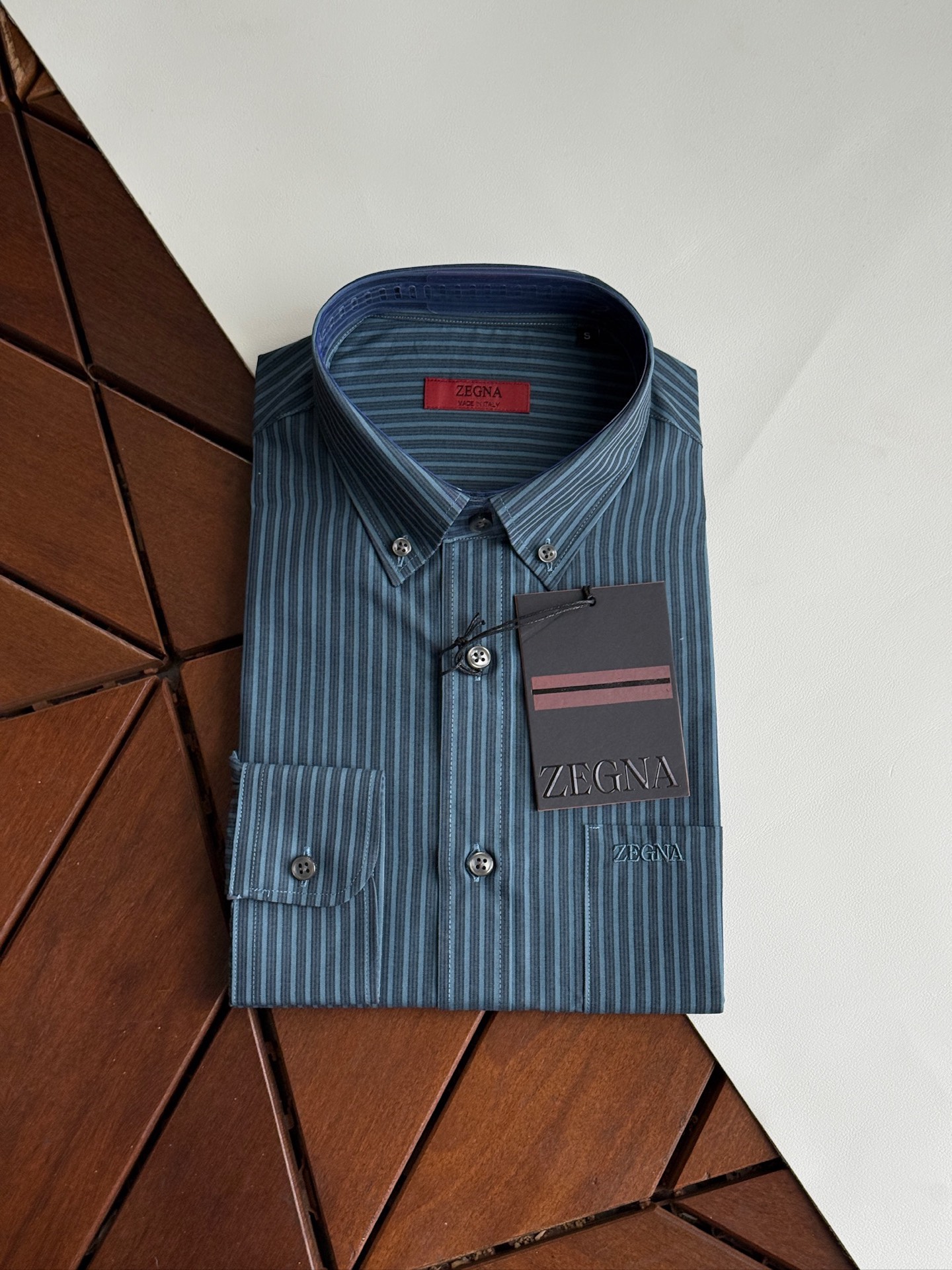 NO:950554,Dark green details are new, the latest model in 2026, Zegna shirts, yarn-dyed stripes, Zegna classics, high-end satin fabric shirts are coming. Zegna spring and summer business men's shirts create a new realm of business, a perfect symphony of touch and style, high-end texture, a business model.  In business occasions, a high-quality shirt is not only the basis of dressing, but also a symbol of taste and temperament. Ermenegildo Zegna cotton-wool blended business shirts, with their excellent quality, exquisite craftsmanship and unique design, have become the best choice for business people.  This shirt is made of classic Lu Thai satin fabric, which is a perfect fusion of softness and comfort of high-quality cotton. The shirt has a crisp, stylish luster and an ultimate touch. It is like a second skin when worn. It is light and breathable, allowing the skin to breathe freely. The addition of cotton enhances the durability and ease of care of the fabric, ensuring that the shirt can be maintained in good condition for daily wear and business trips.  The details show Zegna's ingenuity. The exquisite tailoring fits the curves of the human body, showing an elegant figure; the design of the collar and cuffs is simple and elegant, with smooth lines, showing the sophistication and confidence of business people. The buttons on the shirt are made of high-quality materials and are finely polished. They are full of texture and complement the overall style. Size SMLXLXXL,,zegna,shirts,19860909墨绿色细节 上新,2026年最新款,杰尼亚衬衫 色织条纹 杰尼亚经典款,高级缎纹面料衬衫来袭. 杰尼亚Zegna 春夏商务男士衬衣织就商务新境界,触感与风度的完美交响,高端质感,商务典范. 在商务场合,一件优质的衬衫不仅是着装的基础,更是品味与气质的象征.杰尼亚棉毛混纺商务衬衣,以其卓越的品质、精湛的工艺和独特的设计,成为商务人士的不二之选. 这款衬衣采用了经典的鲁泰缎纹面料,柔顺和优质棉的舒适完美融合.衬衫挺刮有型的光泽和极致的触感,穿着时仿佛第二层肌肤,轻盈透气,让肌肤自由呼吸；而棉的加入则增强了面料的耐用性和易打理性,确保衬衣在日常穿着和商务出行中都能保持良好的状态. 细节之处,尽显杰尼亚的匠心独运.精致的剪裁贴合人体曲线,展现出优雅的身姿；领口和袖口的设计简洁大方,线条流畅,彰显出商务人士的干练与自信.衬衣上的纽扣选用高品质材料,经过精细打磨,质感十足,与整体风格相得益彰. 码数SMLXLXXL,,zegna,shirts,,Men's clothing