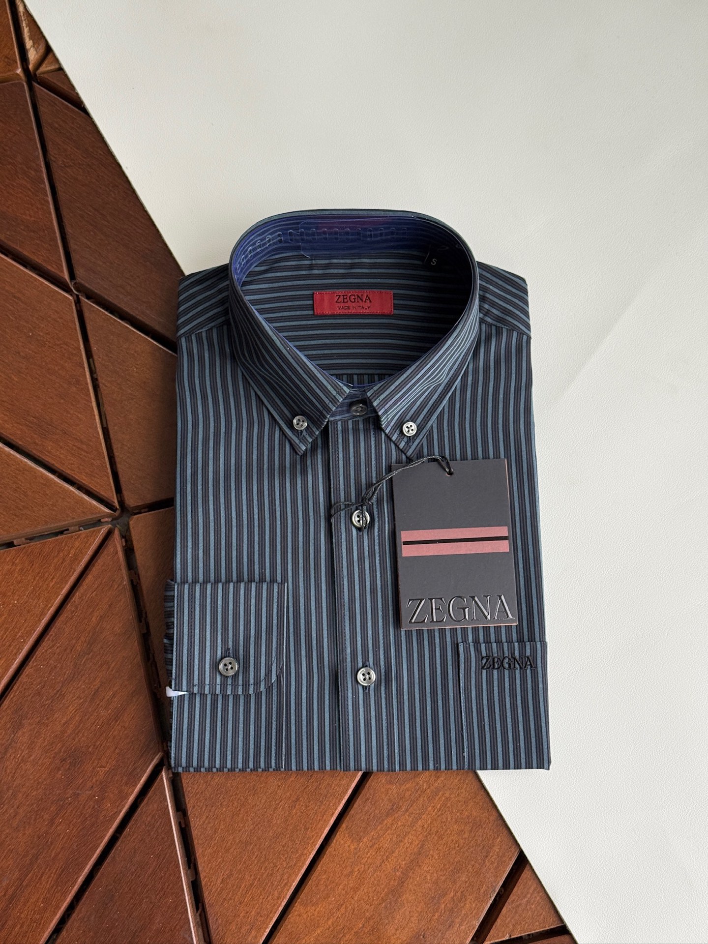 NO:950564,Gray and black details are new, the latest model in 2026, Zegna shirts, yarn-dyed stripes, Zegna classics, high-end satin fabric shirts are coming. Zegna spring and summer business men's shirts create a new realm of business, a perfect symphony of touch and style, high-end texture, a business model.  In business occasions, a high-quality shirt is not only the basis of dressing, but also a symbol of taste and temperament. Ermenegildo Zegna cotton-wool blended business shirts, with their excellent quality, exquisite craftsmanship and unique design, have become the best choice for business people.  This shirt is made of classic Lu Thai satin fabric, which is a perfect fusion of softness and comfort of high-quality cotton. The shirt has a crisp, stylish luster and an ultimate touch. It is like a second skin when worn. It is light and breathable, allowing the skin to breathe freely. The addition of cotton enhances the durability and ease of care of the fabric, ensuring that the shirt can be maintained in good condition for daily wear and business trips.  The details show Zegna's ingenuity. The exquisite tailoring fits the curves of the human body, showing an elegant figure; the design of the collar and cuffs is simple and elegant, with smooth lines, showing the sophistication and confidence of business people. The buttons on the shirt are made of high-quality materials and are finely polished. They are full of texture and complement the overall style. Size SMLXLXXL,,zegna,shirts,19860909灰黑色细节 上新,2026年最新款,杰尼亚衬衫 色织条纹 杰尼亚经典款,高级缎纹面料衬衫来袭. 杰尼亚Zegna 春夏商务男士衬衣织就商务新境界,触感与风度的完美交响,高端质感,商务典范. 在商务场合,一件优质的衬衫不仅是着装的基础,更是品味与气质的象征.杰尼亚棉毛混纺商务衬衣,以其卓越的品质、精湛的工艺和独特的设计,成为商务人士的不二之选. 这款衬衣采用了经典的鲁泰缎纹面料,柔顺和优质棉的舒适完美融合.衬衫挺刮有型的光泽和极致的触感,穿着时仿佛第二层肌肤,轻盈透气,让肌肤自由呼吸；而棉的加入则增强了面料的耐用性和易打理性,确保衬衣在日常穿着和商务出行中都能保持良好的状态. 细节之处,尽显杰尼亚的匠心独运.精致的剪裁贴合人体曲线,展现出优雅的身姿；领口和袖口的设计简洁大方,线条流畅,彰显出商务人士的干练与自信.衬衣上的纽扣选用高品质材料,经过精细打磨,质感十足,与整体风格相得益彰. 码数SMLXLXXL,,zegna,shirts,,Men's clothing