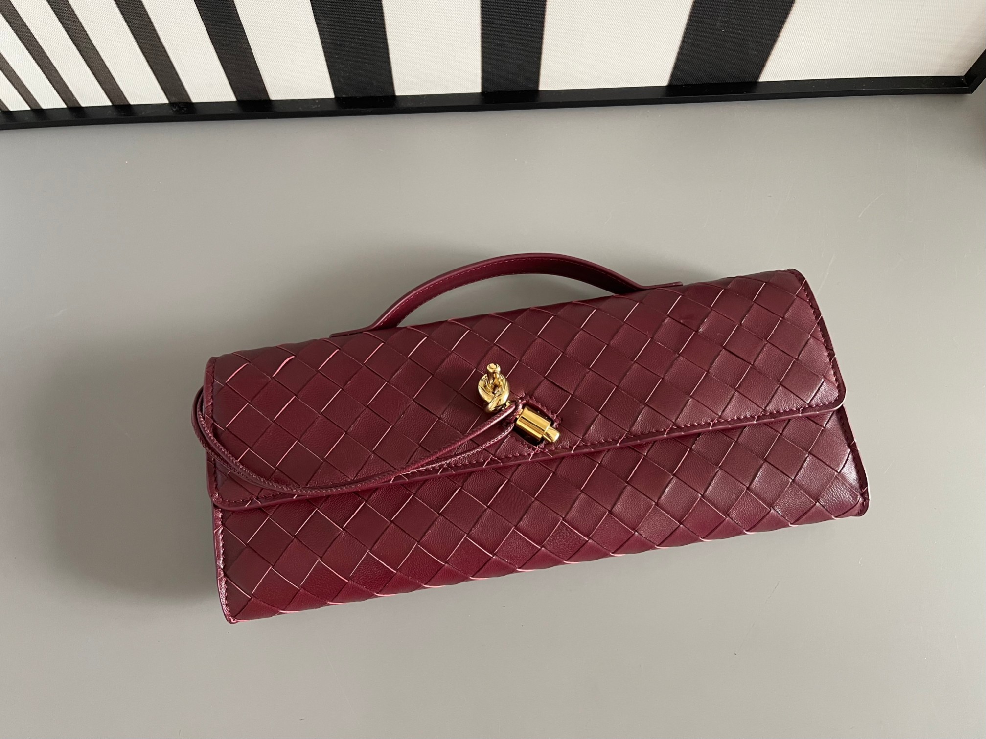 Bottega Veneta Burgundy Bv Clutch long clutch bag 741511 is equipped with handles. The design of the clutch bag reflects the exquisite and high-e