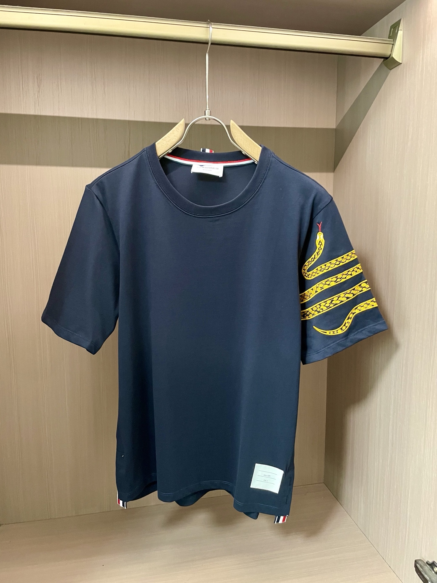 NO:440797,TB 2025 Spring and Summer New Products Simple and Individual. Classic round neck design fits the neck, comfortable and comfortable. The body body is pure, and a bright golden snake pattern is entrenched on one sleeve, lifelike, adding a mysterious and fashionable atmosphere to the whole. The neckline and the hem are red, white and blue, detailing the exquisite style. The fabric is soft and skin-friendly and breathable. A versatile item Size M-XXL, alexander wang19860909TB 2025春夏新品 简约中透着个性.经典圆领设计,贴合颈部,舒适自在.衣身主体纯净,一侧衣袖上盘踞着一条亮眼的金色蛇形图案,栩栩如生,为整体增添神秘与时尚气息.领口和下摆处红白蓝细节点缀,彰显精致格调.面料质感柔软,亲肤透气.百搭单品 尺码M-XXL,,alexander wang,Men's clothing