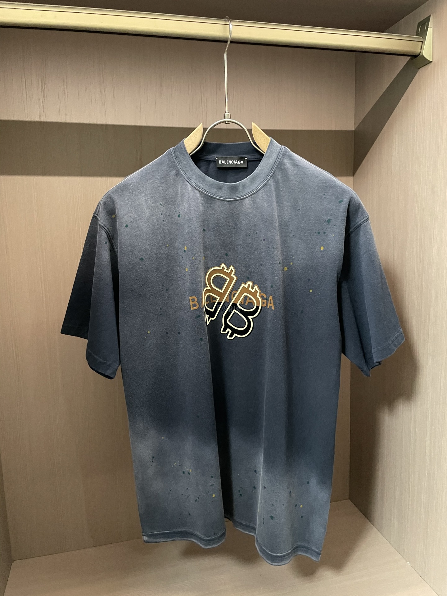 
巴黎世家 做旧渐变 T 恤，灰黑过渡带泼墨感，金色比特币字母标超吸睛。宽松版型，街头潮流感拉满，日常搭
