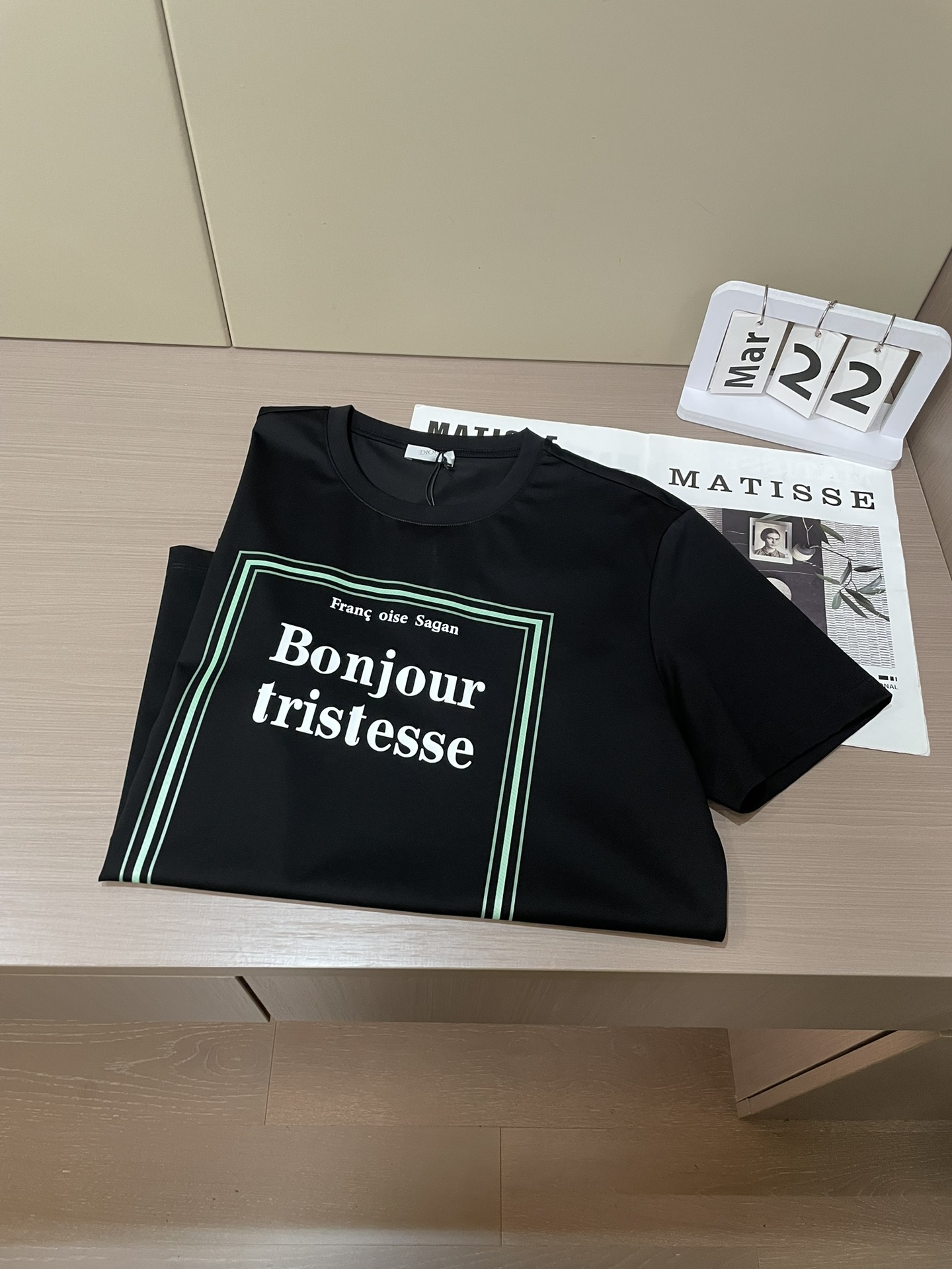 Dior 2026春夏男装系列中的​​文学封面纯色短袖T恤​​，设计灵感源自法国作家弗朗索瓦丝·萨冈（F