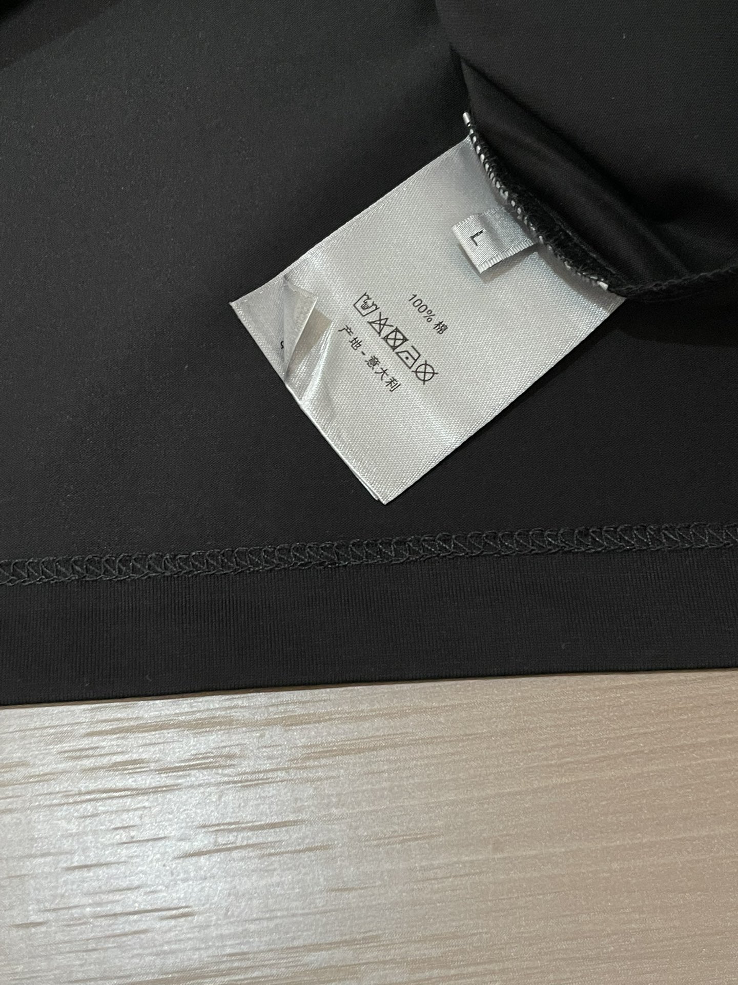 Dior 2026春夏男装系列中的​​文学封面纯色短袖T恤​​，设计灵感源自法国作家弗朗索瓦丝·萨冈（F