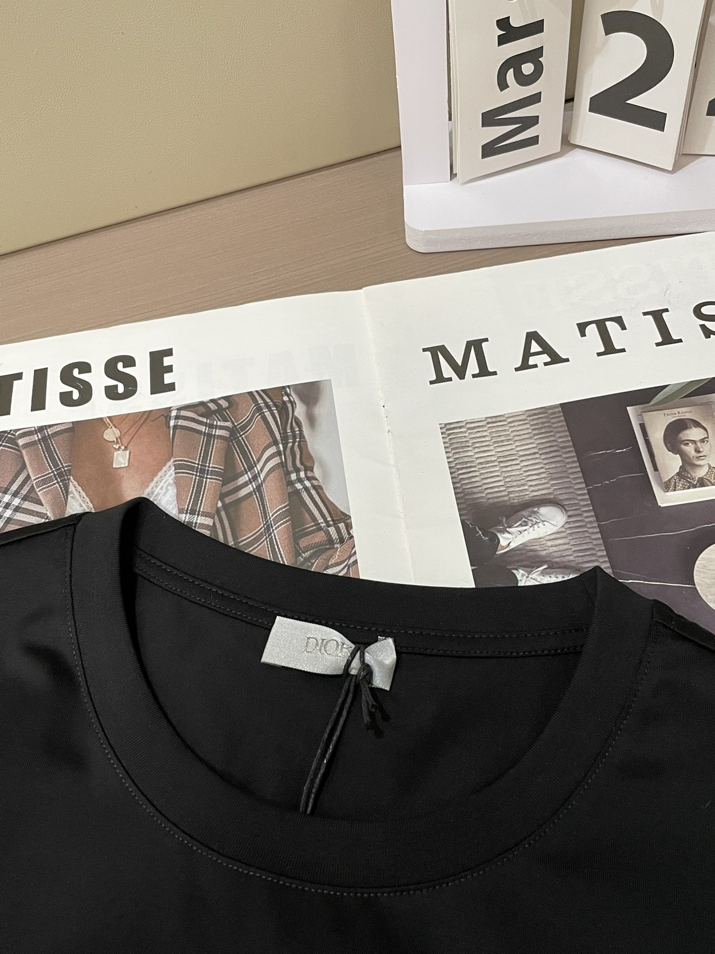 Dior 2026春夏男装系列中的​​文学封面纯色短袖T恤​​，设计灵感源自法国作家弗朗索瓦丝·萨冈（F