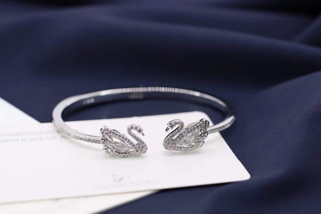 swarovski 白金色 镂空跳动双天鹅手镯这款精致考究的两枚天鹅装饰上缀有闪亮迷人的swarovsk