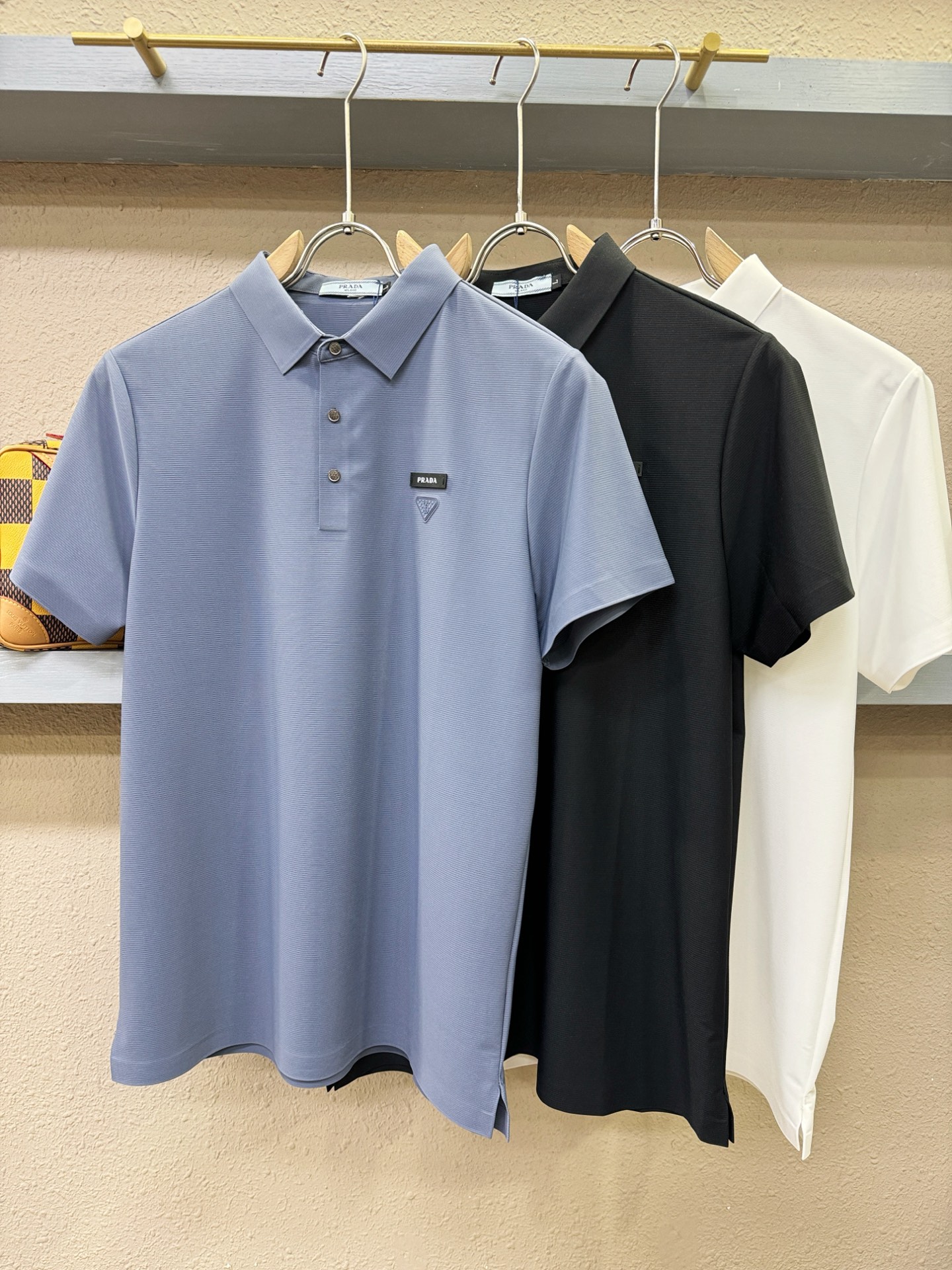 PRADA 普拉达  2026春夏新款首发专柜最新款翻领短袖，冰丝面料，高端订制 设计前卫时尚！品牌logo重工艺设计 
