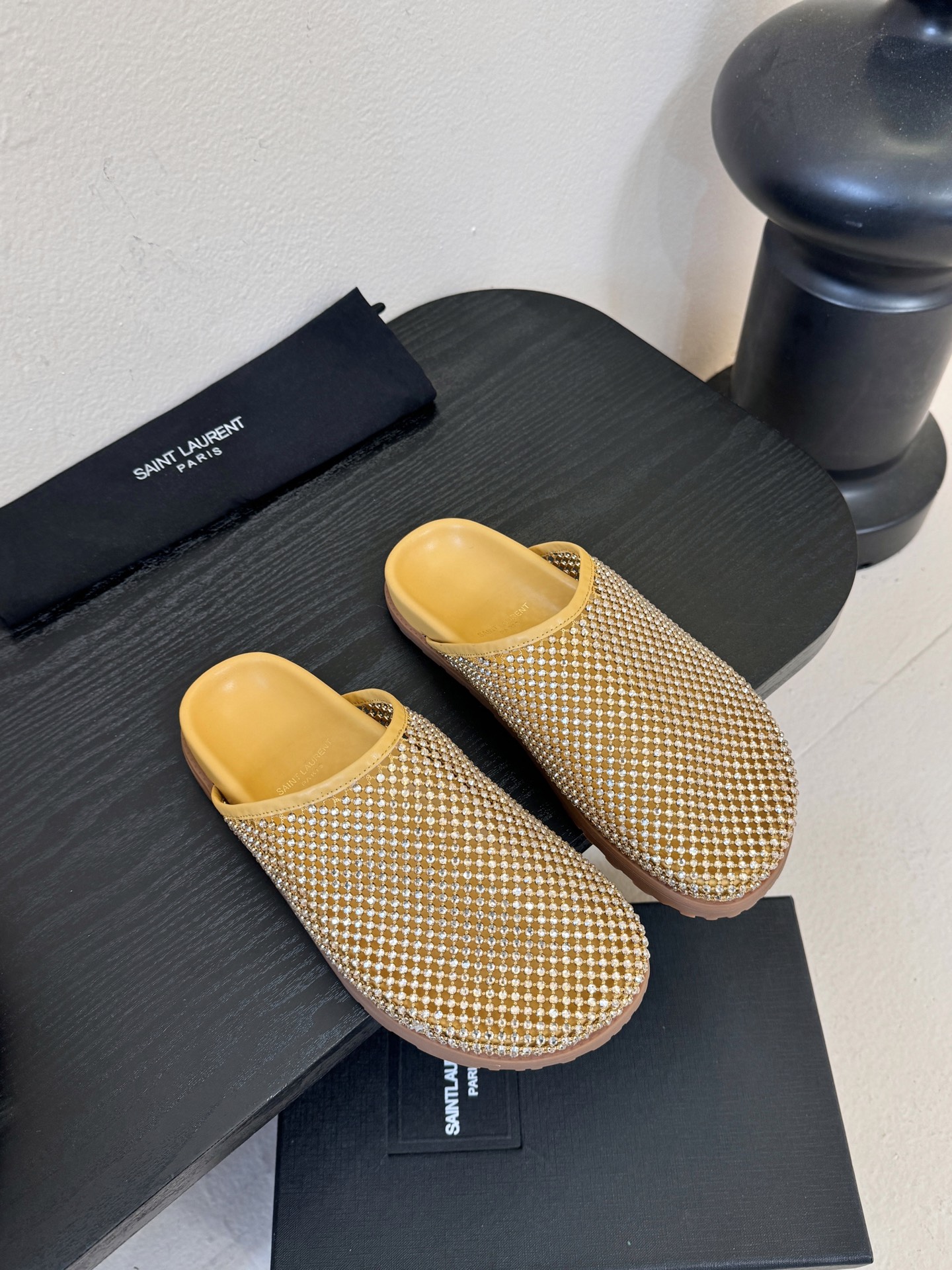 NO:680232,Saintlauren*25ss autumn and winter diamond-faced mules half-slipper casual shoes. The upper is covered with rhinestone decoration, and the diamond face design is arranged in a grid, which has a strong luster. It is launched in two colors: gold and black. The golden shoe body and the lining are the same color, and the black style has a rhinestone face with a black leather lining, which has a sharp visual contrast.  It is a toe-toe Mule half-mug style with no heel design, making it easy to put on and take off with one foot. The shoe shape is a simple flat-bottomed toe-toe style with smooth lines, taking into account practicality and style. The YSL brand logo can be seen inside the shoe, and it uses leather lining and textured sole, continuing the light luxury and exquisite craftsmanship of Yves Saint Laurent, with both fashion and brand recognition. The upper is meshed with mesh, and the lining is sheepskin. The outsole is 2cm taller.  size 35-40 (customized sizes 40 are non-refundable), half drag, saint laurent, saint laurent, saint laurent, slippers, sheepskin19860909Saintlauren*25ss秋冬钻面穆勒半拖鞋休闲鞋 鞋面通体覆盖水钻装饰,采用网格状排列的钻面设计,光泽感强；推出金色、黑色两款配色,金色款鞋身与内里同色,黑色款钻面搭配黑色皮质内里,视觉对比鲜明. 为包头穆勒拖半拖款式,无后跟设计,一脚蹬穿脱便捷；鞋型为简约的平底包头款,线条流畅,兼顾实用性与造型感.鞋内可见YSL品牌标识,采用皮革内里与质感鞋底,延续了圣罗兰轻奢精致的工艺水准,兼具时尚度与品牌辨识度. 鞋面网钻 内里羊皮 大底橡胶大底 增高2cm size35-40码（40码定制不退换）,半拖,saint laurent,saint laurent,saint laurent,slippers,sheepskin,Women's Shoes