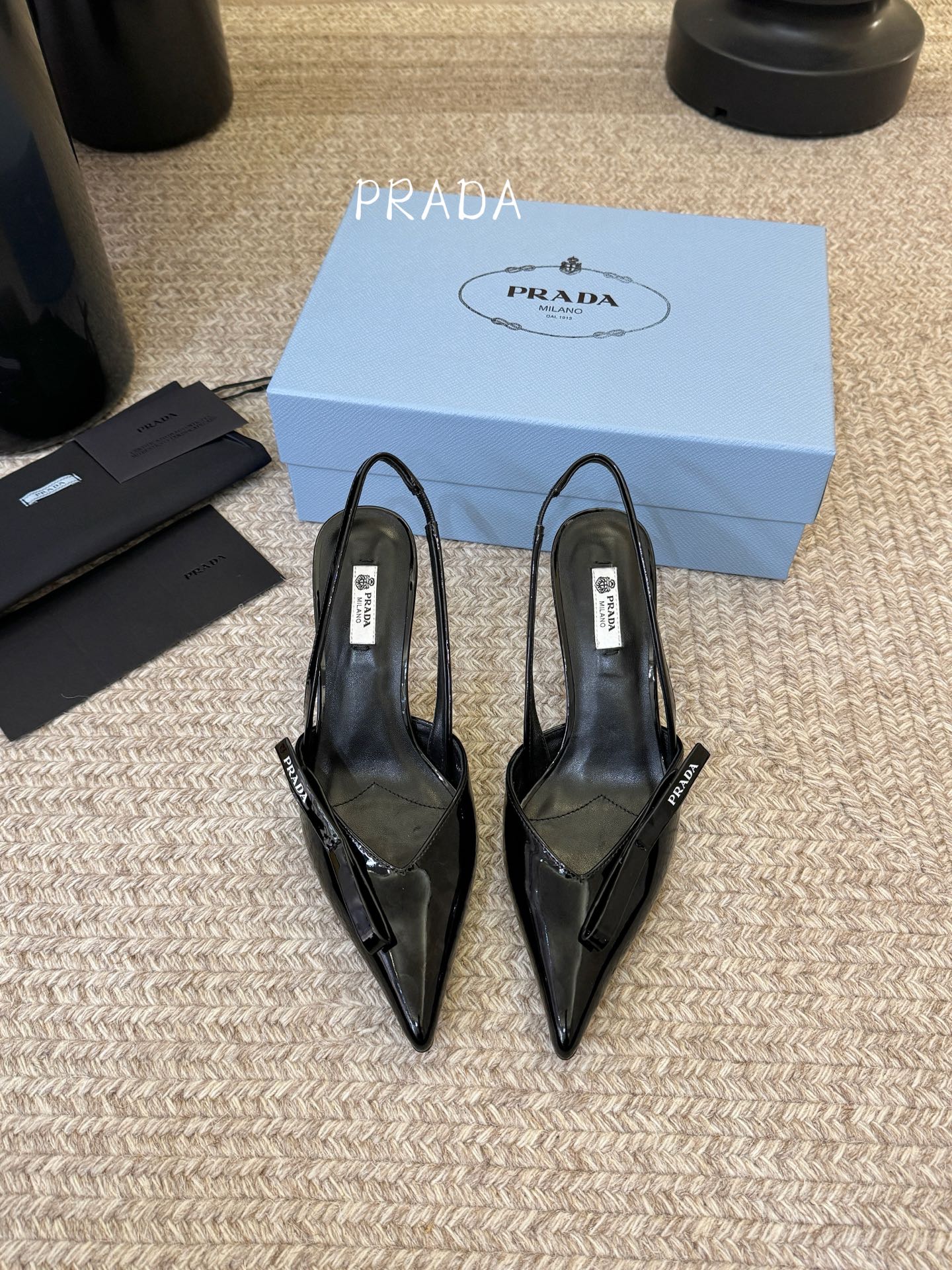 NO:758100,Takagan 7.5 PRAD*25ss retro triangular pointed-toe kitten heel. The Prada triangle logo is embedded in the toe, which is a highly recognizable symbolic element of the brand and strengthens the visual memory point. The pointed-toe outline modifies the foot shape while adding an elegant and capable temperament, which is in line with Prada's consistent exquisite style. The thin strap design at the heel is both decorative and practical. It not only fixes the ankle, improves wearing stability, but also weakens the heavy feeling of high heels.  The heel height is moderate, creating an aura while ensuring walking comfort, suitable for the workplace or daily commuting scenes. The shoes are lined with genuine leather, which is skin-friendly and breathable, reducing the stuffiness and friction discomfort caused by long-term wear. Patent leather upper, sheepskin lining, leather outsole, size 35-41 (customized sizes 40 and 41 are non-refundable), high-heeled sandals, prada, sandals, high heels, sheepskin, Leather soles19860909高根7.5 PRAD*25ss 复古三角标尖头小猫跟 鞋头处嵌入Prada三角徽标,这是品牌辨识度极高的符号元素,强化视觉记忆点.采用尖头轮廓,修饰脚型的同时增添优雅干练气质,契合Prada一贯的精致风格.后跟处的细带设计兼顾装饰性与实用性,既固定脚踝、提升穿着稳定性,又弱化高跟鞋的厚重感. 鞋跟高度适中,在营造气场的同时保障行走舒适度,适合职场或日常通勤场景.鞋内采用真皮衬里,亲肤透气,减少长时间穿着的闷热感与摩擦不适感. 鞋面漆皮 内里羊皮 大底真皮大底 size35-41码（40、41码定制不退换）,高跟鞋凉鞋,prada,sandals,high heels,sheepskin,Leather soles,Women's Shoes