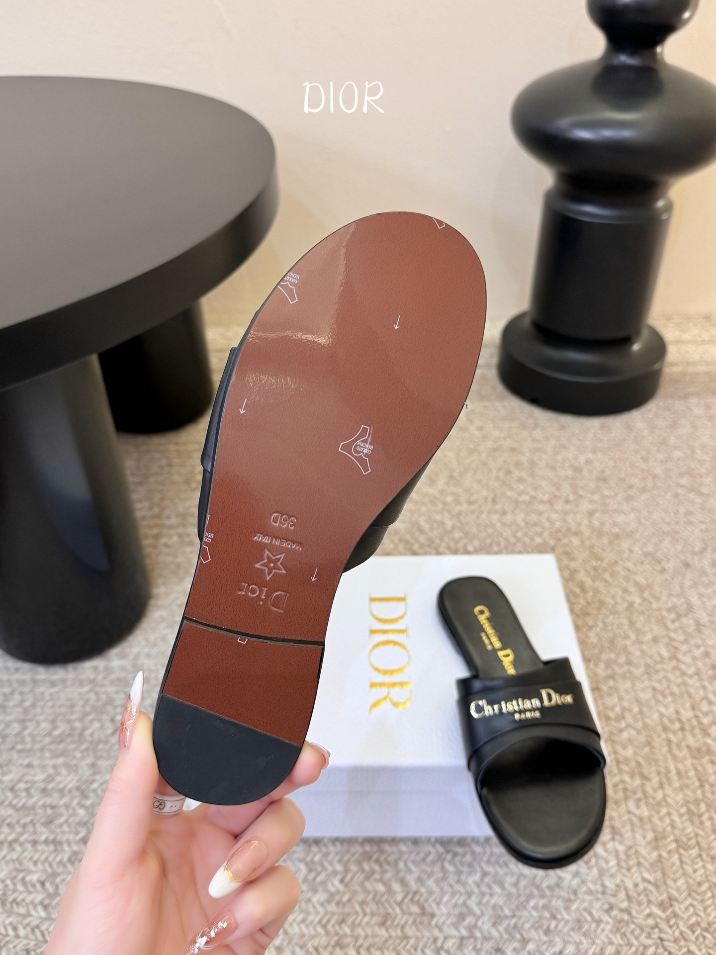 Dio* 新款CD标志平底拖鞋以简约优雅的设计重新诠释经典款式。鞋面精致的金色调叠层牛皮革饰带点缀以交叉