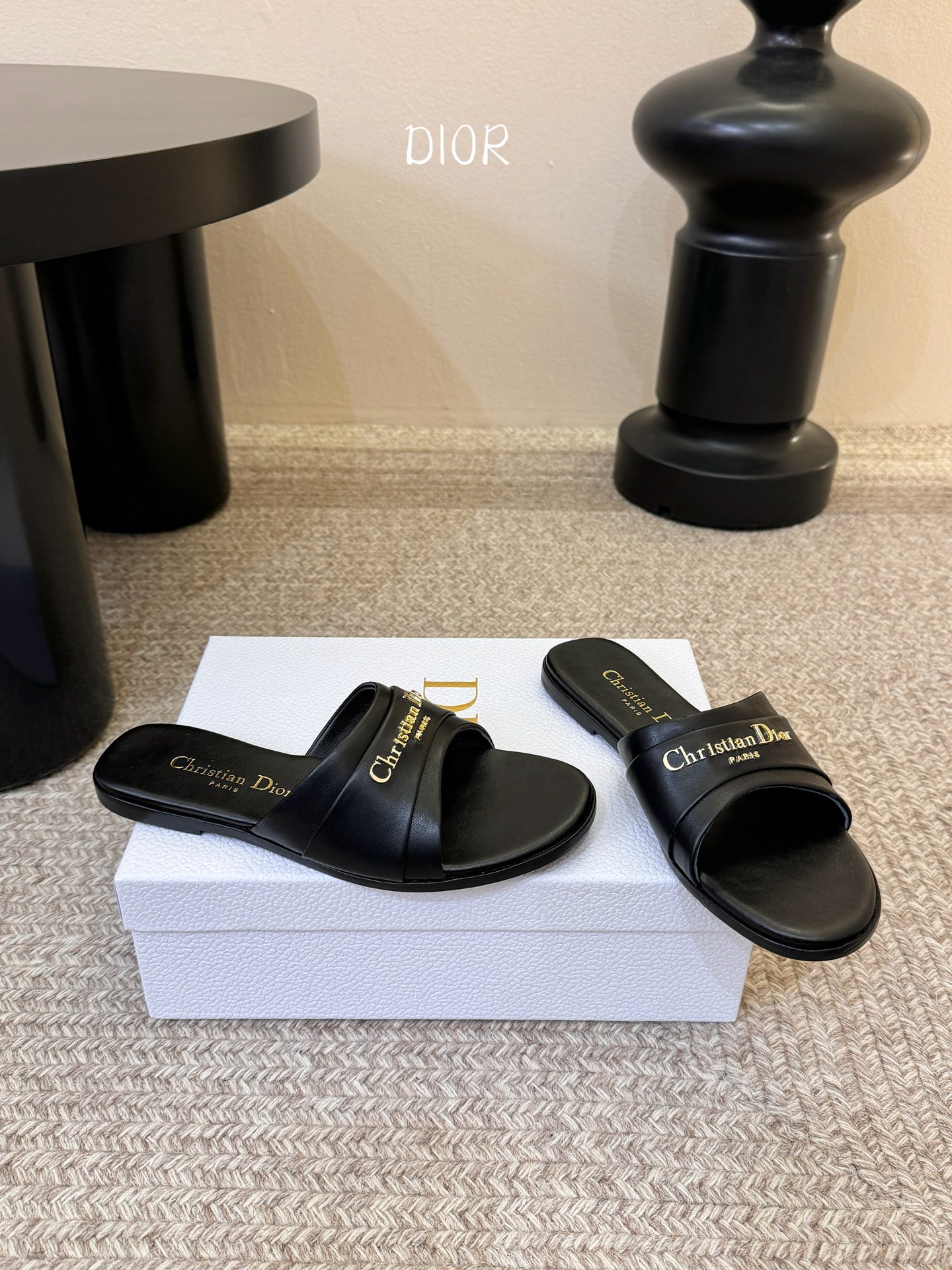 Dio* 新款CD标志平底拖鞋以简约优雅的设计重新诠释经典款式。鞋面精致的金色调叠层牛皮革饰带点缀以交叉