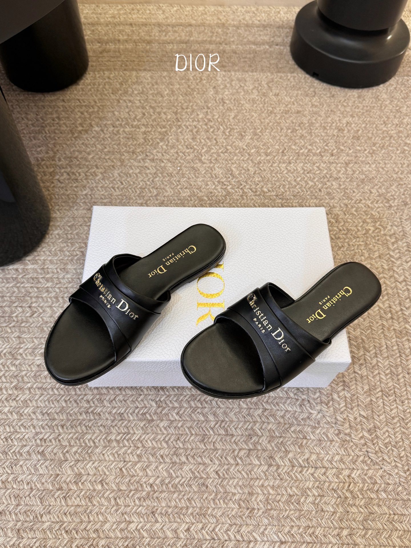 Dio* 新款CD标志平底拖鞋以简约优雅的设计重新诠释经典款式。鞋面精致的金色调叠层牛皮革饰带点缀以交叉