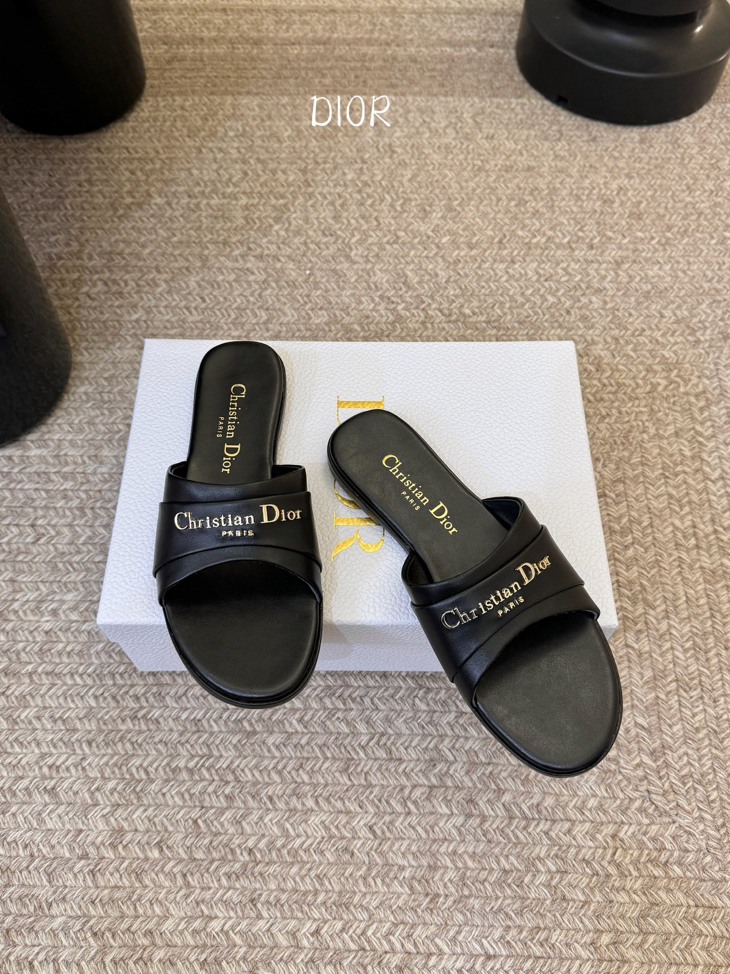 Dio* 新款CD标志平底拖鞋以简约优雅的设计重新诠释经典款式。鞋面精致的金色调叠层牛皮革饰带点缀以交叉