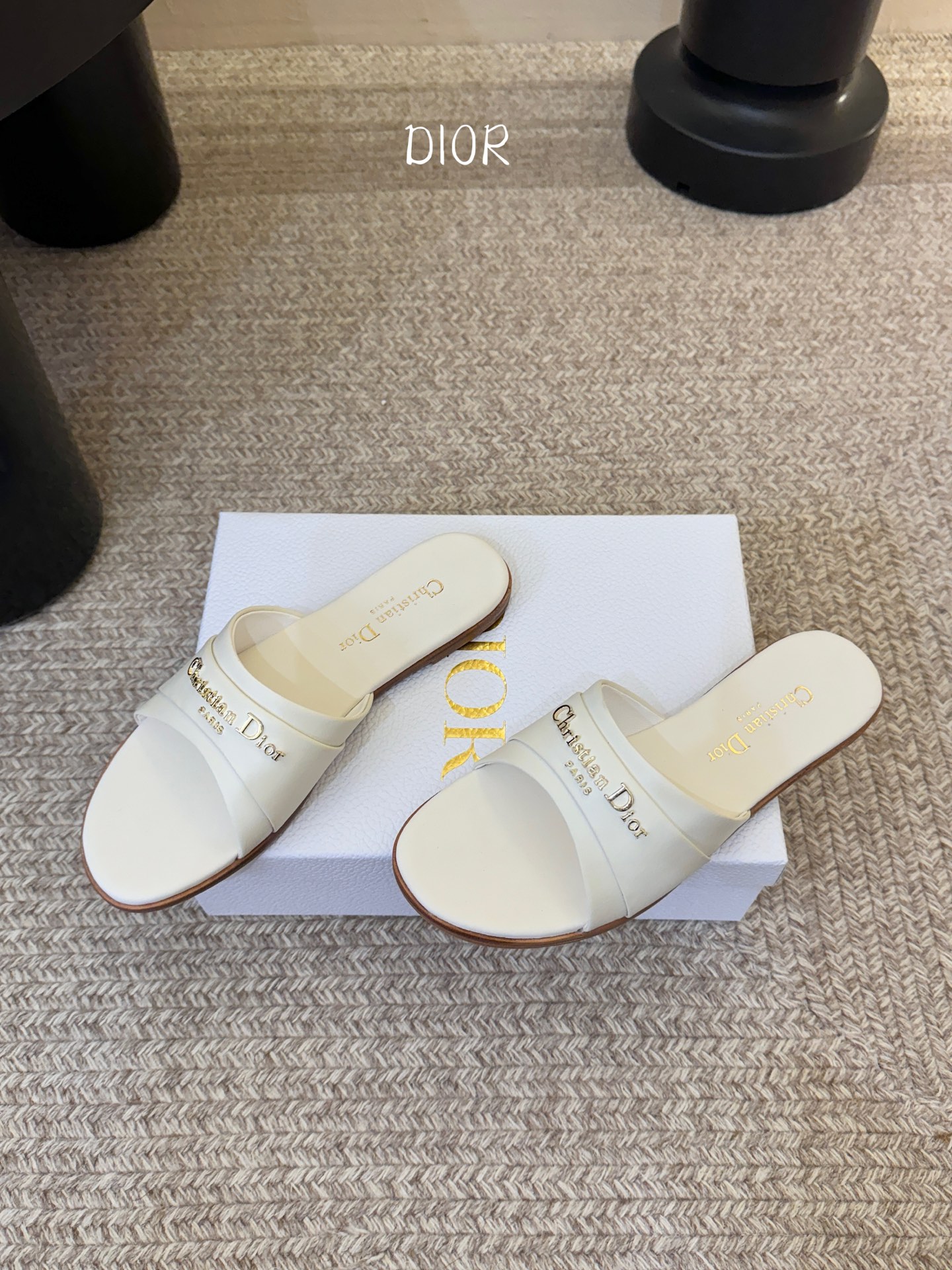 Dio* 新款CD标志平底拖鞋以简约优雅的设计重新诠释经典款式。鞋面精致的金色调叠层牛皮革饰带点缀以交叉