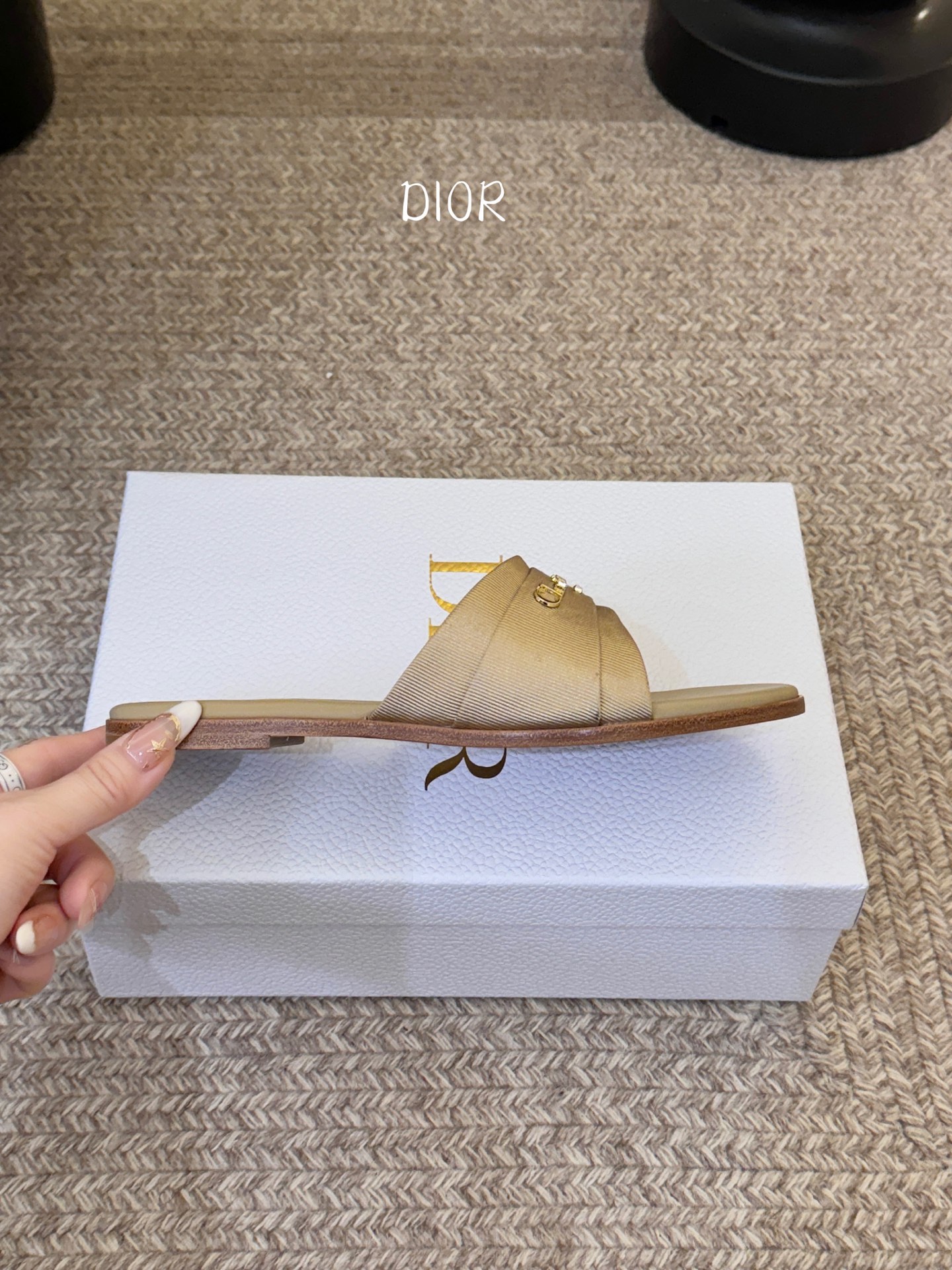 Dio* 新款CD标志平底拖鞋以简约优雅的设计重新诠释经典款式。鞋面精致的金色调叠层牛皮革饰带点缀以交叉