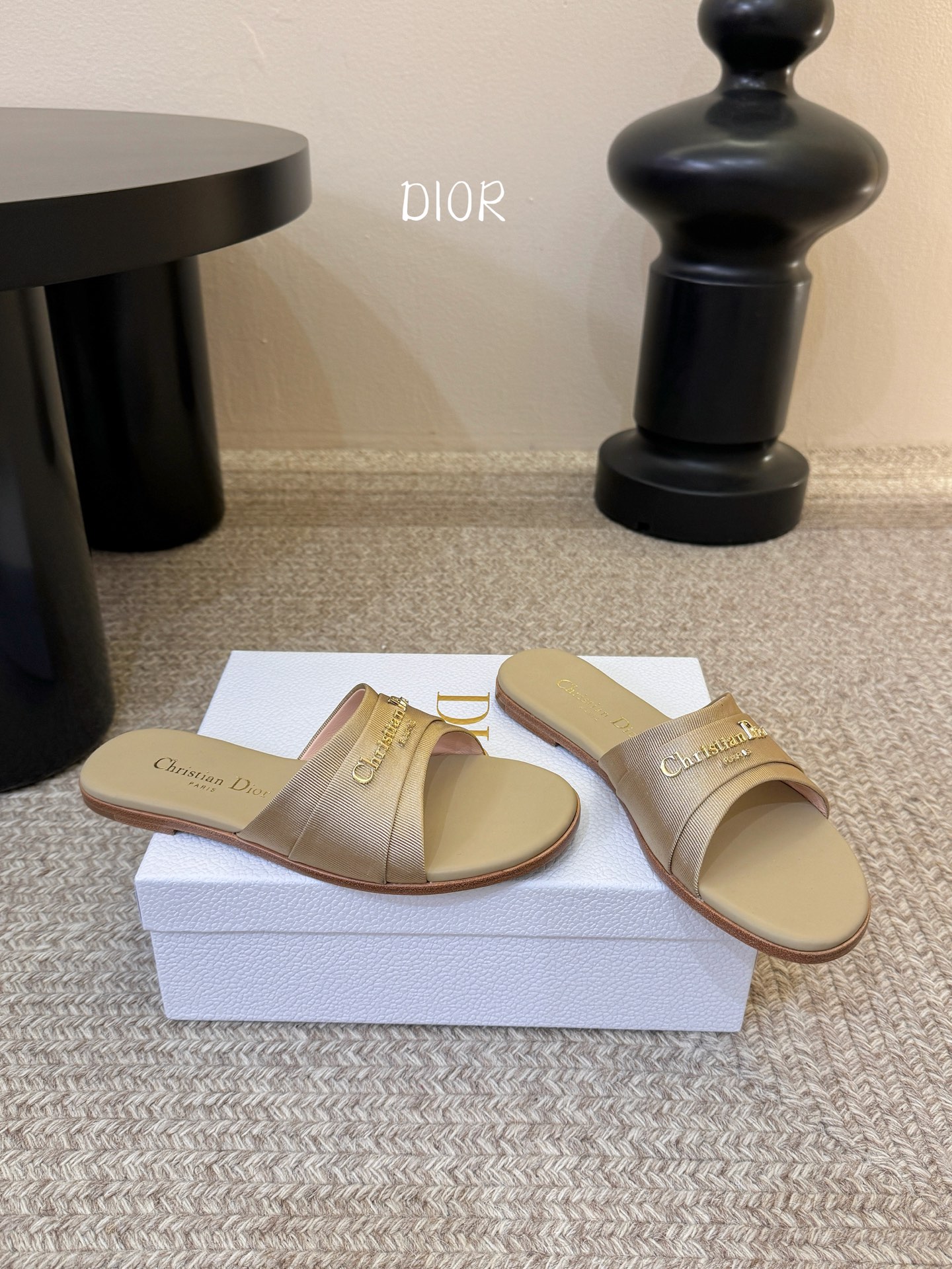 Dio* 新款CD标志平底拖鞋以简约优雅的设计重新诠释经典款式。鞋面精致的金色调叠层牛皮革饰带点缀以交叉