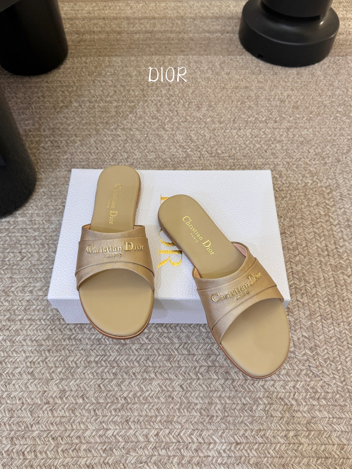 Dio* 新款CD标志平底拖鞋以简约优雅的设计重新诠释经典款式。鞋面精致的金色调叠层牛皮革饰带点缀以交叉