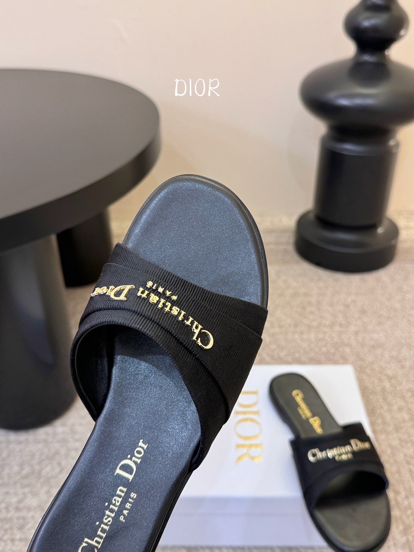 Dio* 新款CD标志平底拖鞋以简约优雅的设计重新诠释经典款式。鞋面精致的金色调叠层牛皮革饰带点缀以交叉