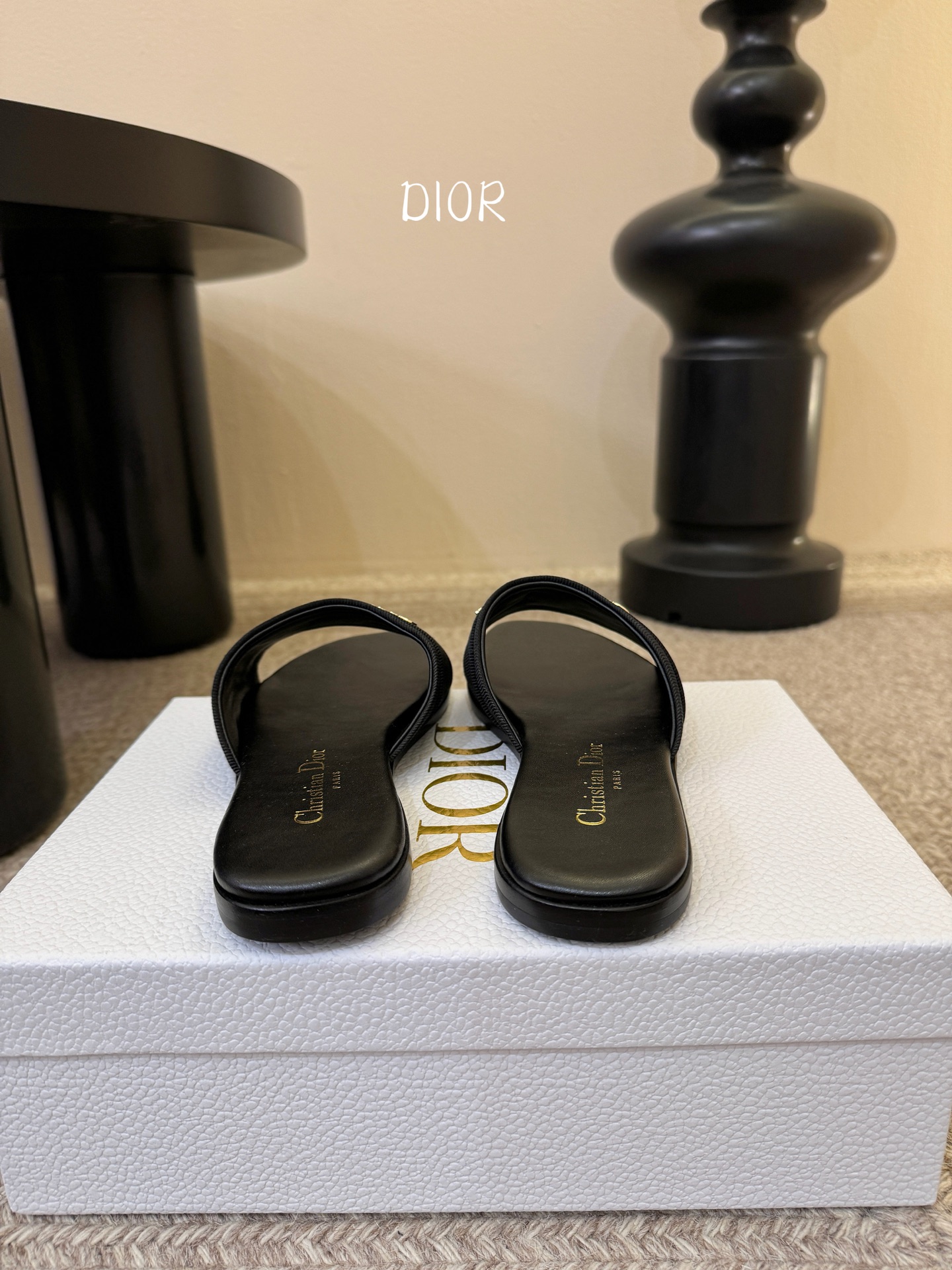 Dio* 新款CD标志平底拖鞋以简约优雅的设计重新诠释经典款式。鞋面精致的金色调叠层牛皮革饰带点缀以交叉