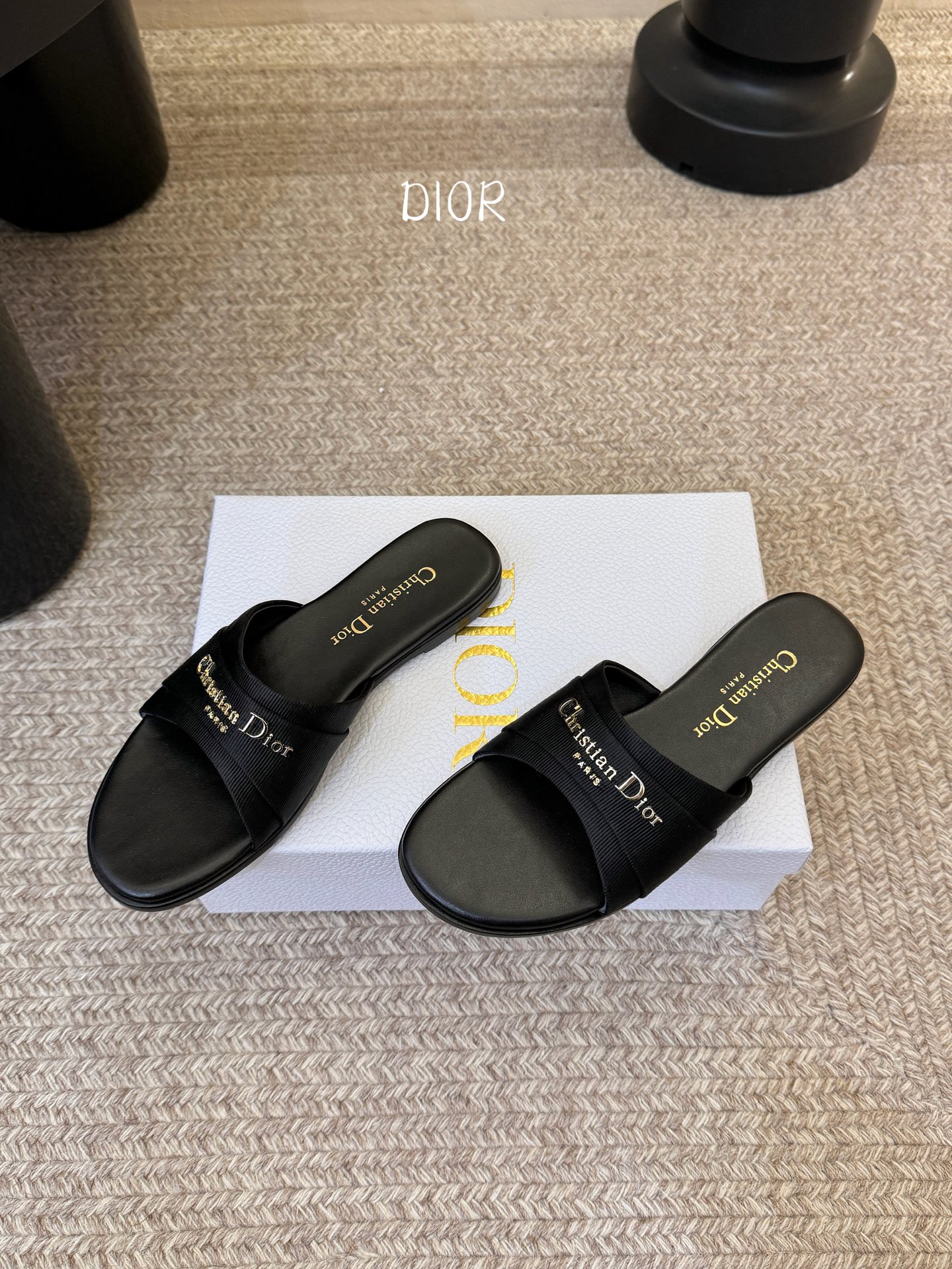 Dio* 新款CD标志平底拖鞋以简约优雅的设计重新诠释经典款式。鞋面精致的金色调叠层牛皮革饰带点缀以交叉