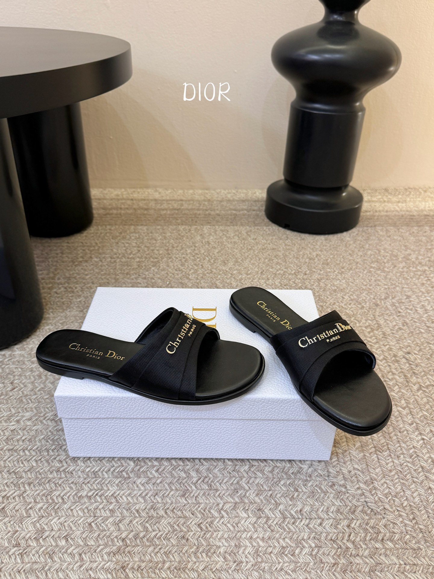 Dio* 新款CD标志平底拖鞋以简约优雅的设计重新诠释经典款式。鞋面精致的金色调叠层牛皮革饰带点缀以交叉