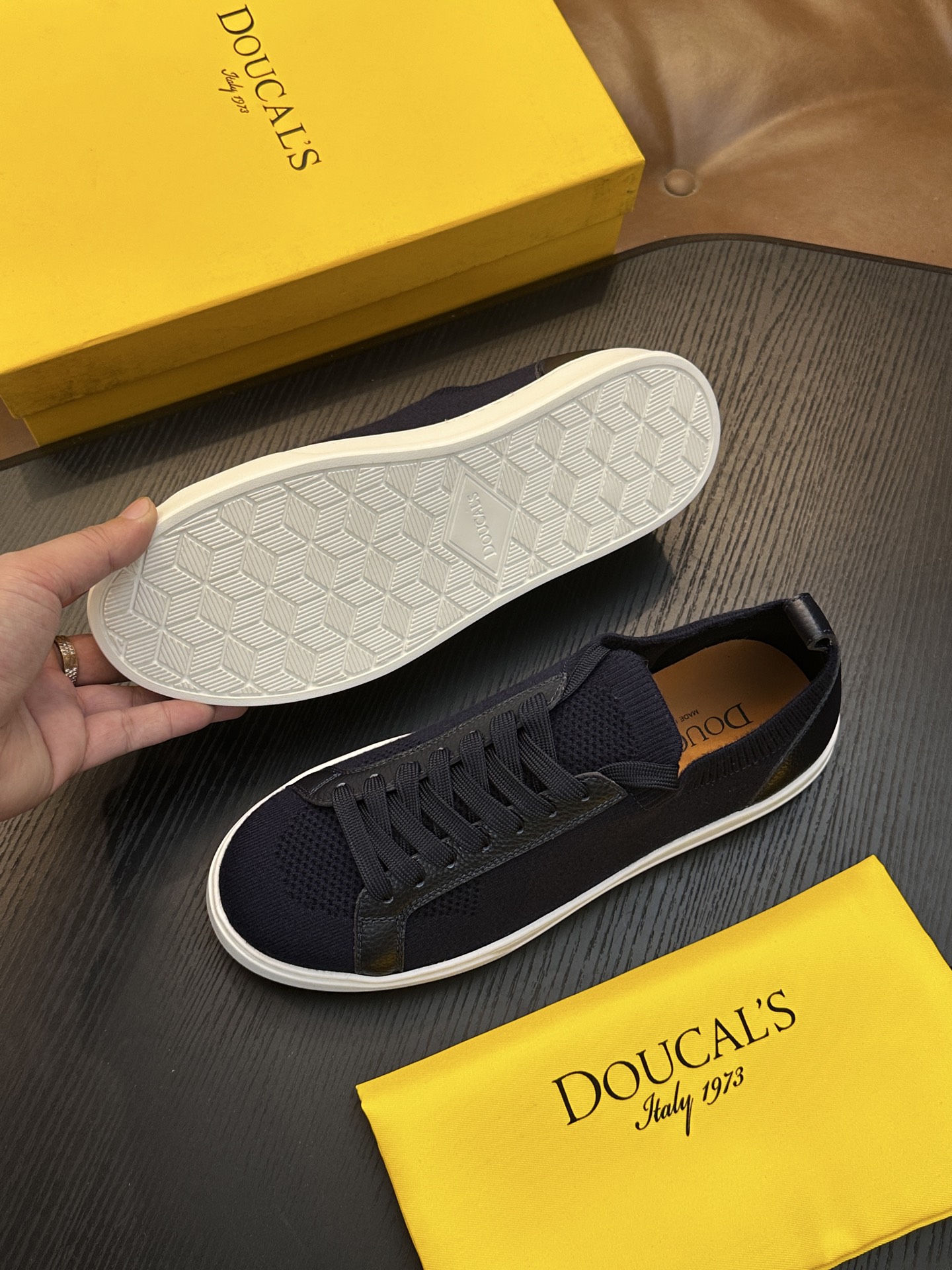 Doucal's针织运动鞋珍贵纱启发了新运动鞋的设计，全棉针织鞋面以现代方式诠释经典款式。半抛光小牛皮饰条凸显在薄而舒适