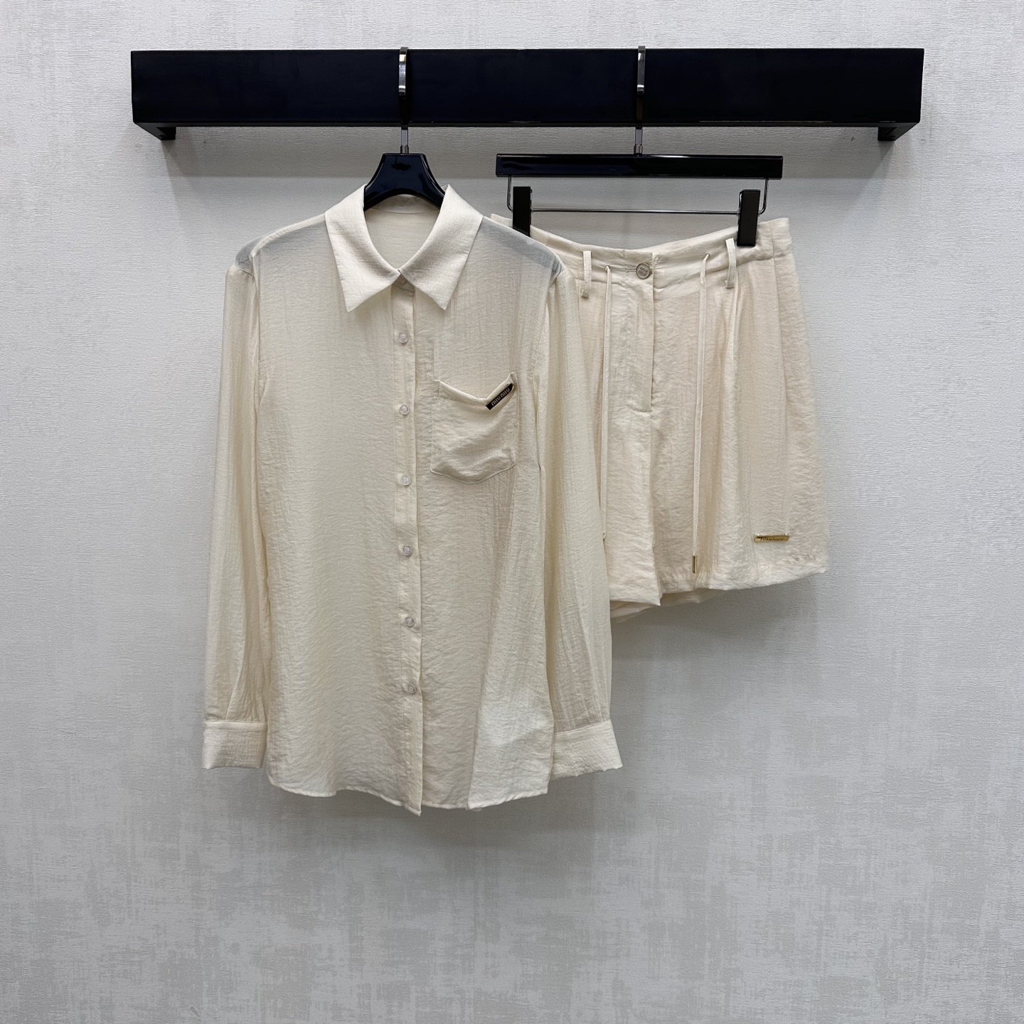 NO:760253,Miumi*2026 new product sun protection shirt and shorts set customized YB imported light rayon material, skin-friendly and comfortable, elegant and smooth, button adjustment at the placket and elastic waist drawstring design, adding layering to the look. Iconic letter metal logo decoration on the chest pocket and trouser leg side highlights the brand tone. Development of surface accessories. Regular shirt paired with high-waisted buttoned shorts set. Relaxed and fashionable, with a full sense of socialite and old money. The upper body of the set is elegant and lazy.  For home and outdoor wear, high version 2 colors, miumiu, shorts, shirts,19860909Miumi*2026新品上架防晒衬衣短裤套装定制YB进口轻薄人丝材质 亲肤舒适 飘逸垂顺 开襟纽扣调节与腰头抽绳松紧设计 增添造型层次感 胸前口袋裤脚侧点缀标志性字母金属徽标装饰 彰显品牌调性 面辅料开发 常规衬衫搭配高腰系扣短裤套装 松弛时髦 带有满满名媛老钱感 成套上身典雅慵懒 家居外穿都 高版本2色,,miumiu,shorts,shirts,,Women's clothing