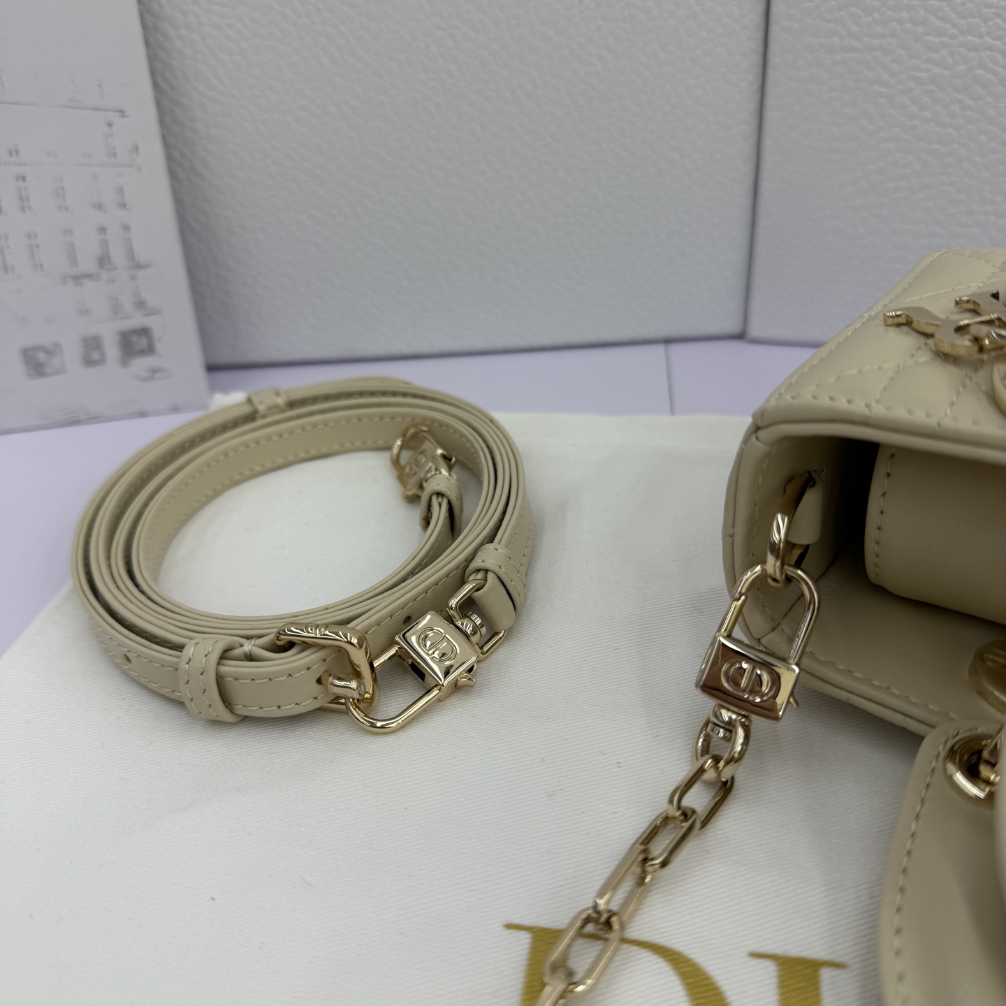 Lady D-Joy 手袋_ 编号: M0910_浅米色
这款 Lady D-Joy 超迷你手袋凸显 Lady Dior 系列的简约美学，集中体现了 Dior 对优雅和美丽的深刻洞见。采用浅米色羊皮革精心制作，饰以藤格纹缉面线，点缀以浅金色饰面金属 D.I.O.R. 吊饰提升格调，时髦典雅的设计经久不衰。搭配可拆卸的链条肩带和可调节、可拆卸的皮革肩带，可手提、肩背或斜挎，是日常或晚装造型的理想之选。
主体：羊皮革
里料：羊皮革
D.I.O.R. 吊饰
可拆卸链条肩带
可调节、可拆卸的皮革肩带
编号: S0910
意大利制造
尺寸：16 x 9 x 5 厘米（长 x 高 x 宽）
可收纳 1 部手机、1 个卡夹和唇膏
肩带长度：92 - 108 厘米
肩带顶端至手袋顶端长度：44 - 51 厘米
链条长度：46 厘米
链条顶端至手袋顶端长度：20 厘米
顶部手柄长度：18.5 厘米
顶部手柄顶端至手袋顶端长度：5.5 厘米
重量：400 克
尺寸和重量详情可能因产品材质而有所不同