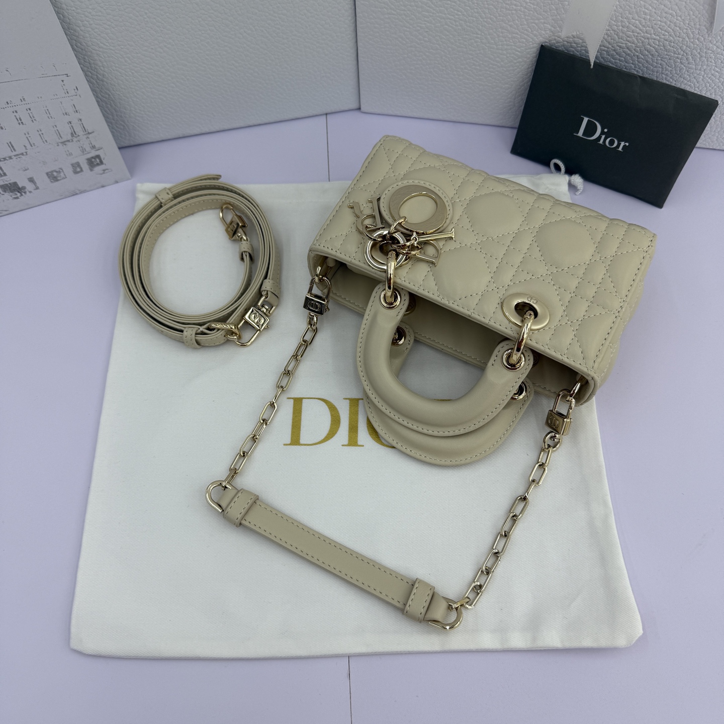 Lady D-Joy 手袋_ 编号: M0910_浅米色
这款 Lady D-Joy 超迷你手袋凸显 Lady Dior 系列的简约美学，集中体现了 Dior 对优雅和美丽的深刻洞见。采用浅米色羊皮革精心制作，饰以藤格纹缉面线，点缀以浅金色饰面金属 D.I.O.R. 吊饰提升格调，时髦典雅的设计经久不衰。搭配可拆卸的链条肩带和可调节、可拆卸的皮革肩带，可手提、肩背或斜挎，是日常或晚装造型的理想之选。
主体：羊皮革
里料：羊皮革
D.I.O.R. 吊饰
可拆卸链条肩带
可调节、可拆卸的皮革肩带
编号: S0910
意大利制造
尺寸：16 x 9 x 5 厘米（长 x 高 x 宽）
可收纳 1 部手机、1 个卡夹和唇膏
肩带长度：92 - 108 厘米
肩带顶端至手袋顶端长度：44 - 51 厘米
链条长度：46 厘米
链条顶端至手袋顶端长度：20 厘米
顶部手柄长度：18.5 厘米
顶部手柄顶端至手袋顶端长度：5.5 厘米
重量：400 克
尺寸和重量详情可能因产品材质而有所不同