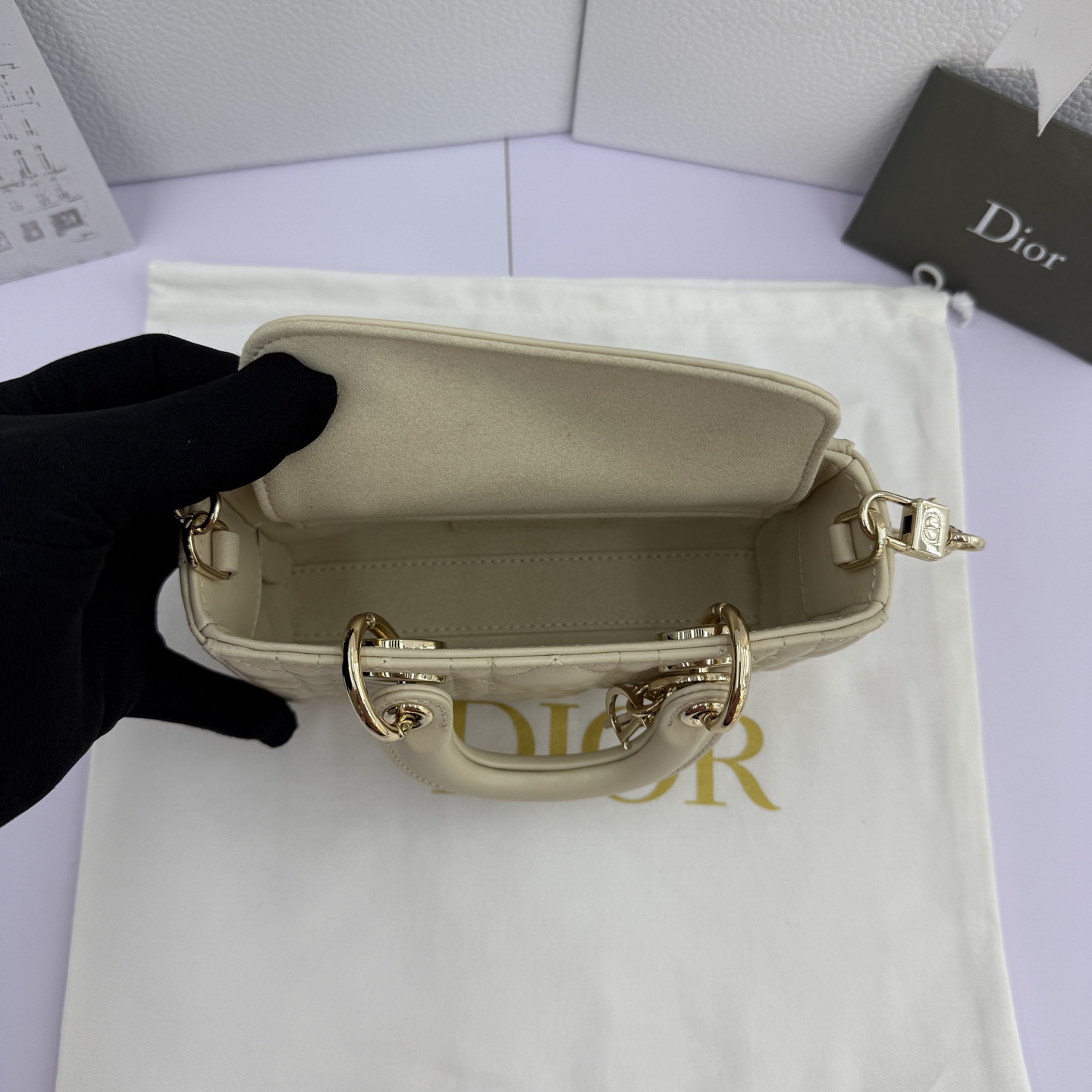 Lady D-Joy 手袋_ 编号: M0910_浅米色
这款 Lady D-Joy 超迷你手袋凸显 Lady Dior 系列的简约美学，集中体现了 Dior 对优雅和美丽的深刻洞见。采用浅米色羊皮革精心制作，饰以藤格纹缉面线，点缀以浅金色饰面金属 D.I.O.R. 吊饰提升格调，时髦典雅的设计经久不衰。搭配可拆卸的链条肩带和可调节、可拆卸的皮革肩带，可手提、肩背或斜挎，是日常或晚装造型的理想之选。
主体：羊皮革
里料：羊皮革
D.I.O.R. 吊饰
可拆卸链条肩带
可调节、可拆卸的皮革肩带
编号: S0910
意大利制造
尺寸：16 x 9 x 5 厘米（长 x 高 x 宽）
可收纳 1 部手机、1 个卡夹和唇膏
肩带长度：92 - 108 厘米
肩带顶端至手袋顶端长度：44 - 51 厘米
链条长度：46 厘米
链条顶端至手袋顶端长度：20 厘米
顶部手柄长度：18.5 厘米
顶部手柄顶端至手袋顶端长度：5.5 厘米
重量：400 克
尺寸和重量详情可能因产品材质而有所不同